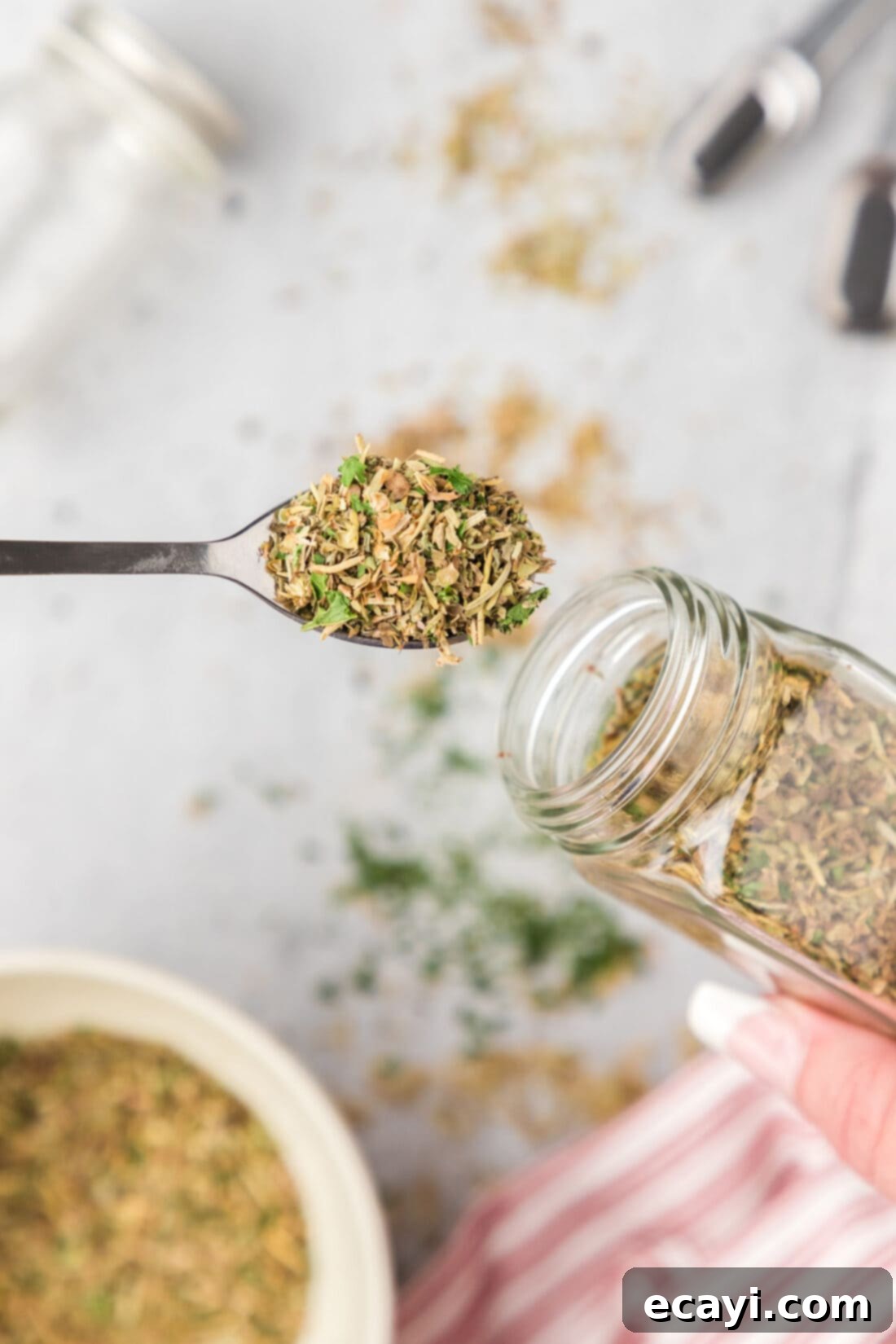 Classic Italian Herb Blend 3 Spoonful of Italian Seasoning pulled out of a seasoning jar, showcasing its rich texture and color.