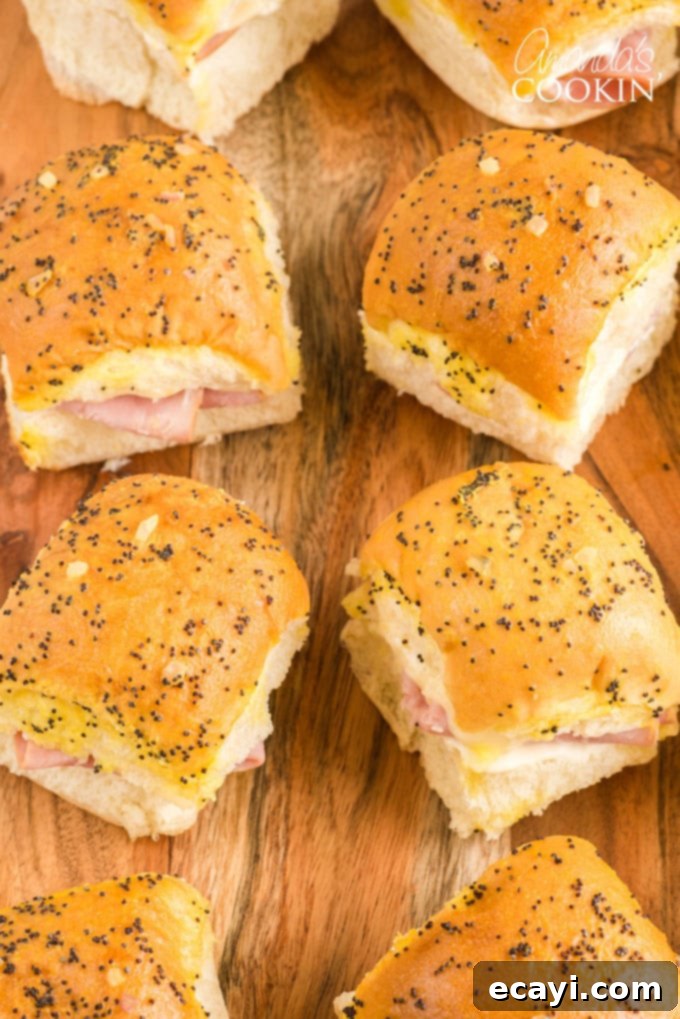 Ham and Cheese Sliders are the perfect appetizer for football parties, potlucks, New Year's Eve, or any other reason to get together and celebrate! Overhead view of freshly baked ham and cheese sliders in a pan, ready to serve.