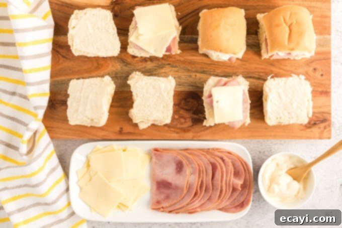 Ultimate Ham and Cheese Sliders 2 Various ingredients for ham and cheese sliders including Hawaiian rolls, ham, cheese, and mayonnaise.