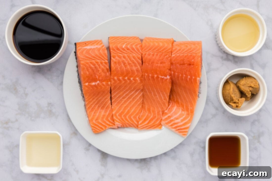 Miso Glazed Salmon 4 A vibrant selection of fresh ingredients including salmon fillets, white miso paste, soy sauce, sesame oil, sake, rice vinegar, cornstarch, water, and green onions laid out for Miso Salmon recipe preparation