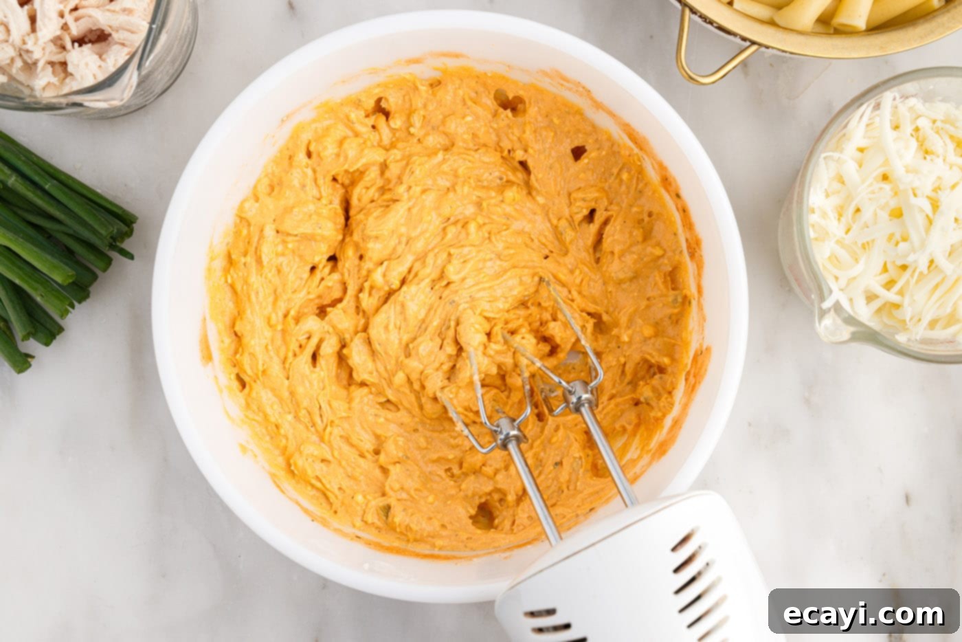 Fiery Chicken Comfort Bake 6 combining buffalo chicken ingredients with a mixer