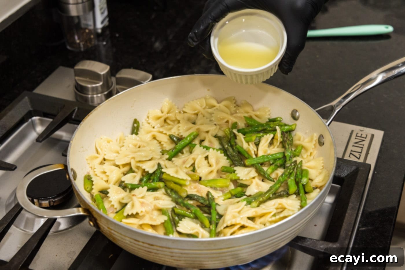Bright Asparagus Pasta 10 Fresh lemon juice being poured over the asparagus pasta in a skillet for a bright finish.