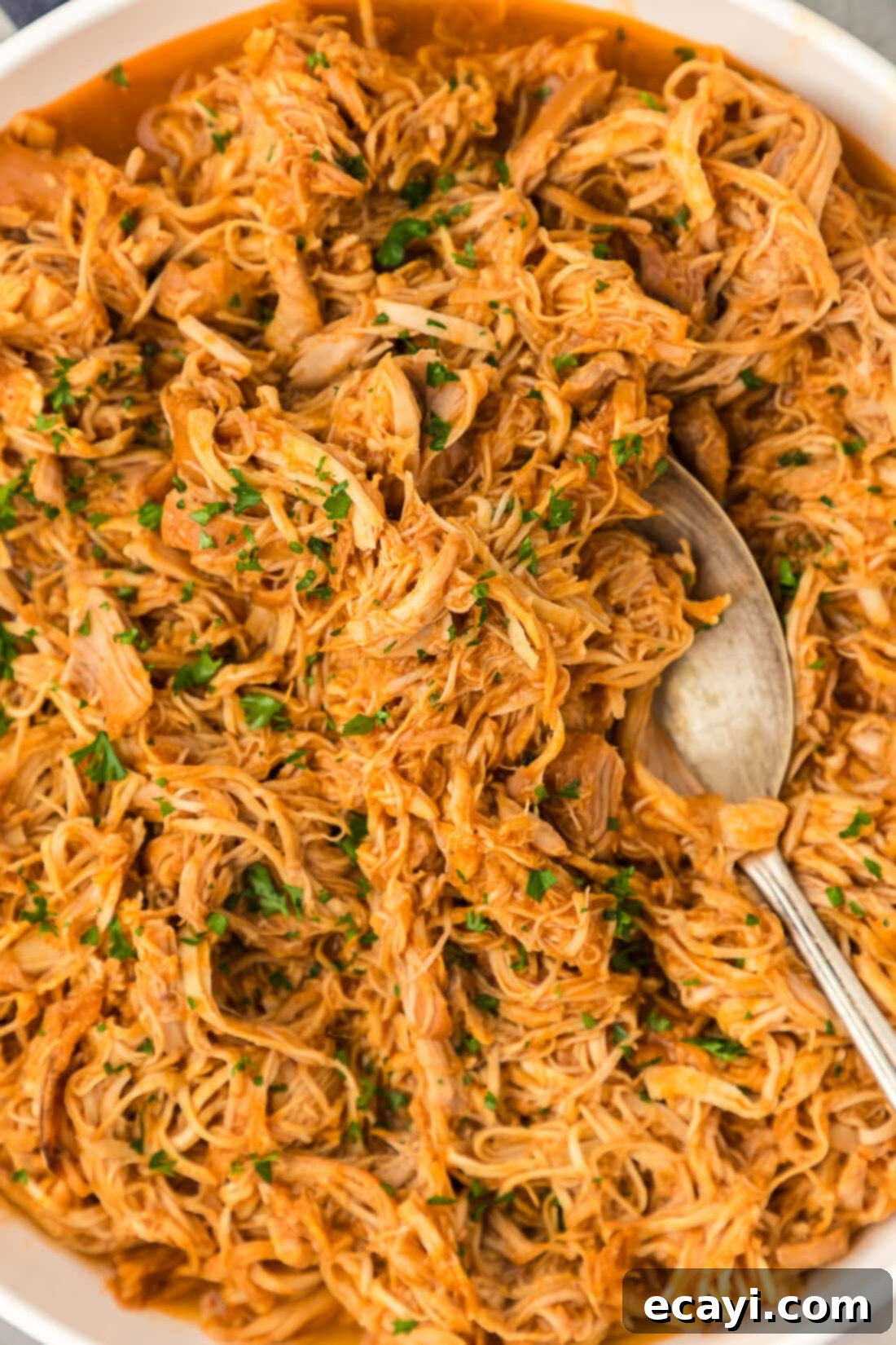 Tender Instant Pot BBQ Chicken 2 Close up photo of Instant Pot BBQ Chicken with a spoon in it, showcasing its rich texture and glossy sauce.