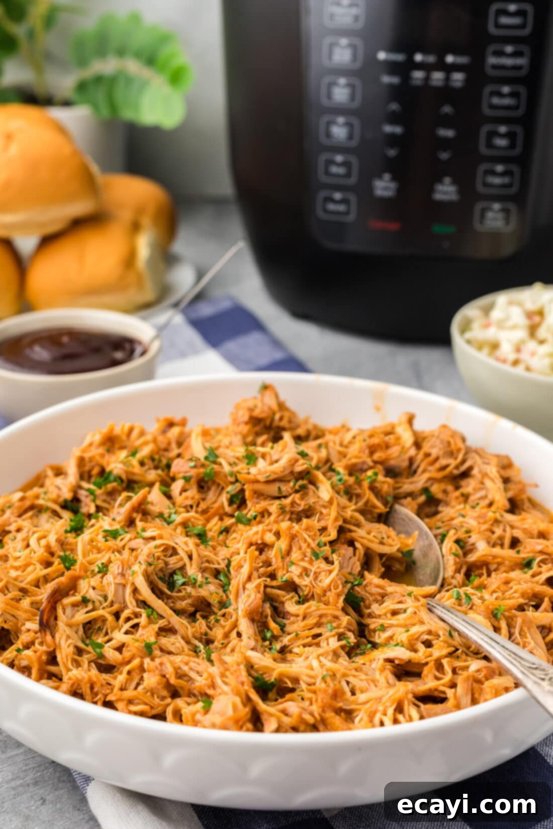 Tender Instant Pot BBQ Chicken 3 Instant Pot BBQ Chicken in a bowl with a serving spoon, ready to be enjoyed.