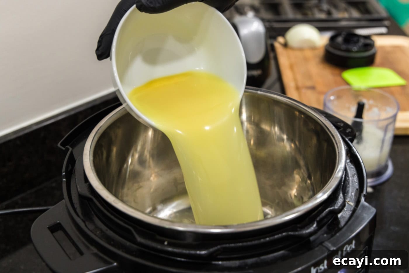 Tender Instant Pot BBQ Chicken 7 Pouring chicken stock into the Instant Pot inner pot.