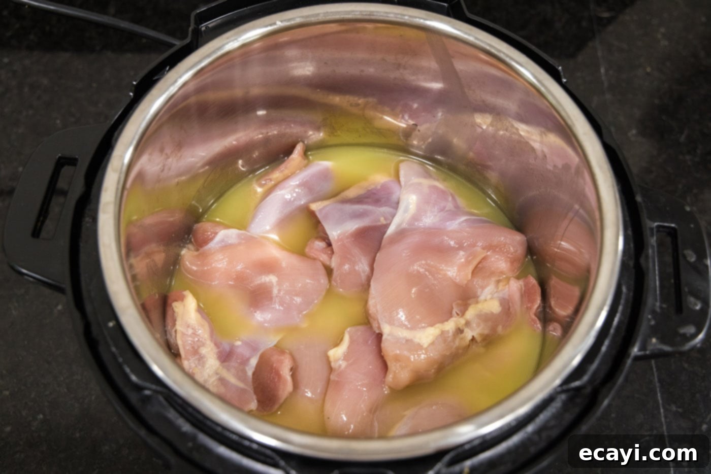 Tender Instant Pot BBQ Chicken 8 Chicken breasts and thighs submerged in chicken stock inside the Instant Pot.