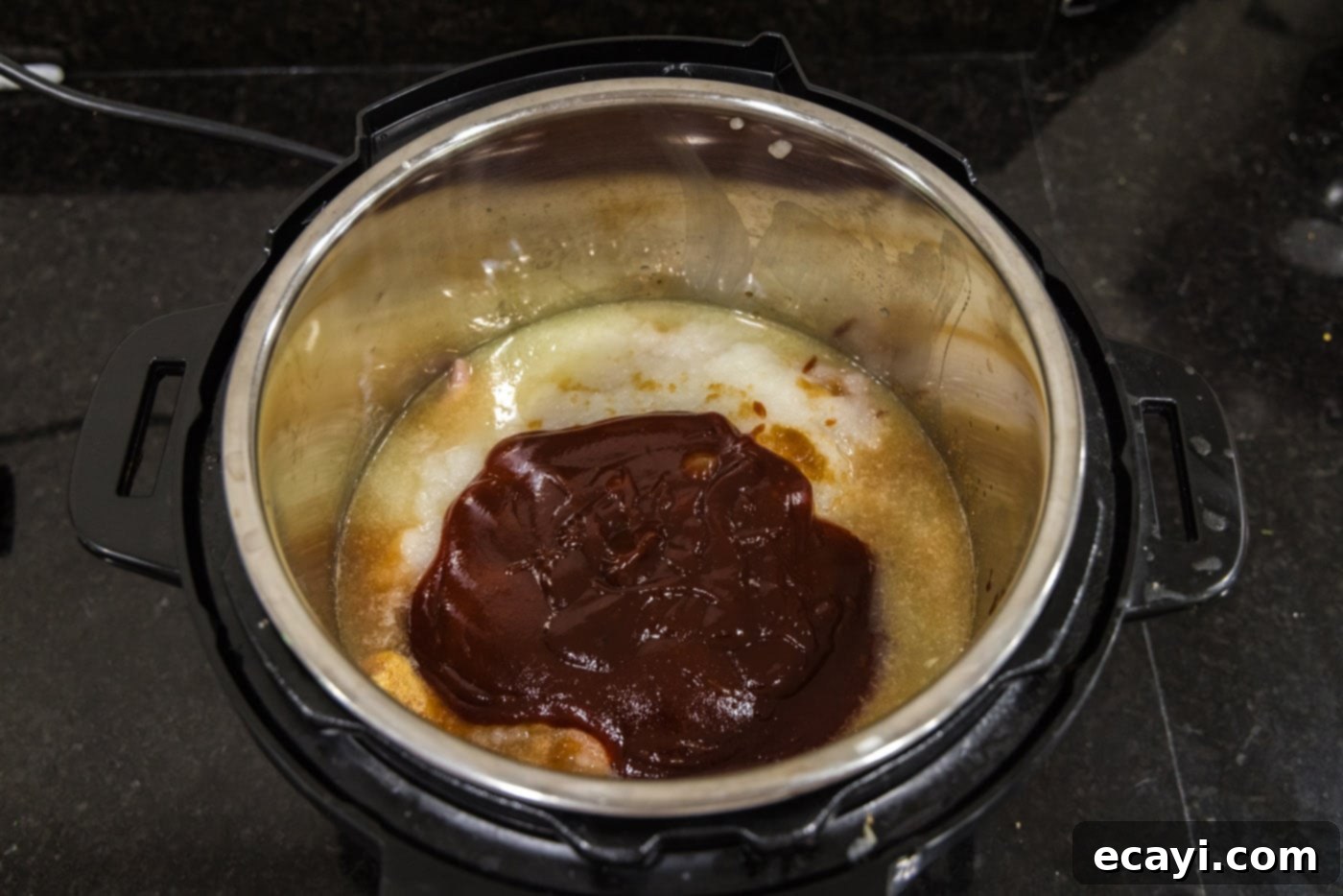 Tender Instant Pot BBQ Chicken 10 Barbecue sauce being added as the final layer on top of all ingredients in the Instant Pot.