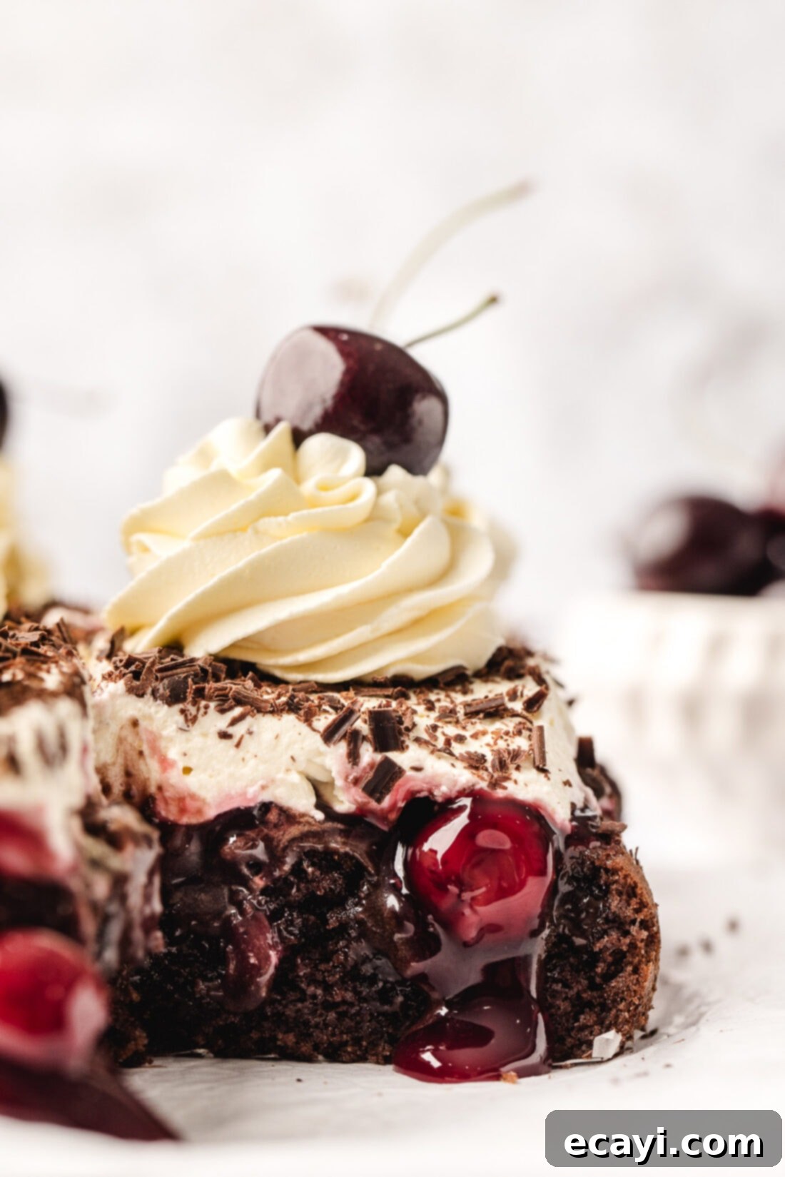 Decadent Black Forest Poke Cake 2 Piece of Black Forest Poke Cake with cherries and chocolate shavings