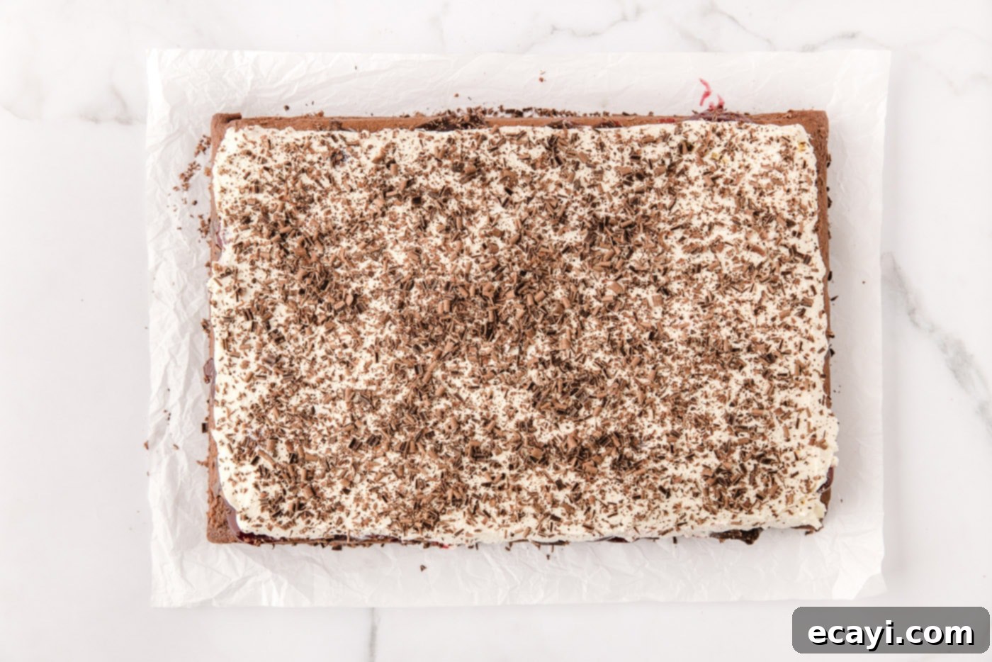 Decadent Black Forest Poke Cake 13 chocolate shavings on top of whipped cream over black forest poke cake