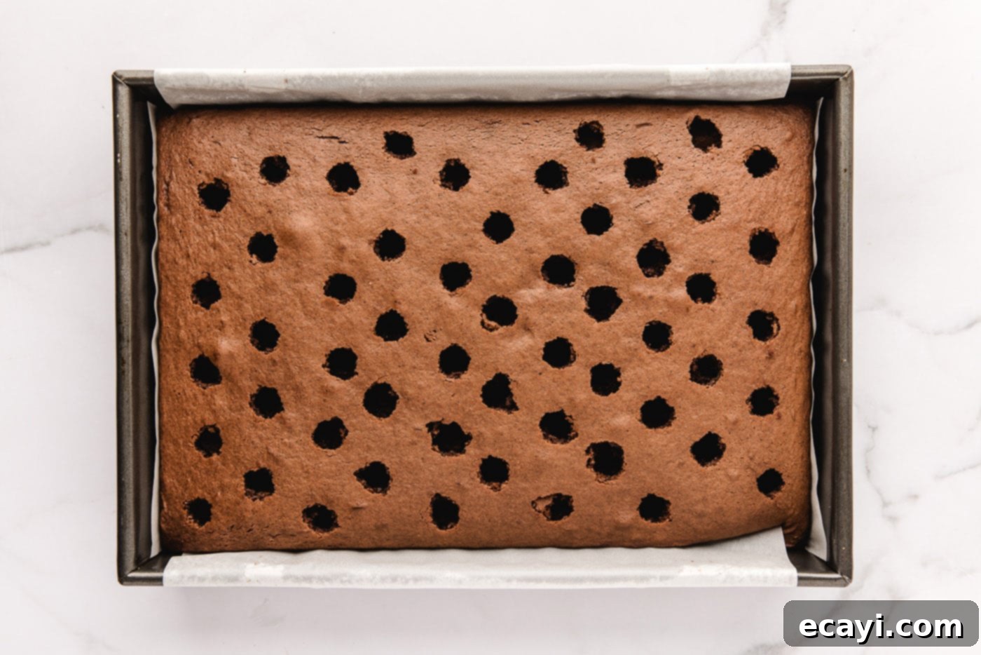 Decadent Black Forest Poke Cake 7 poked holes in chocolate cake