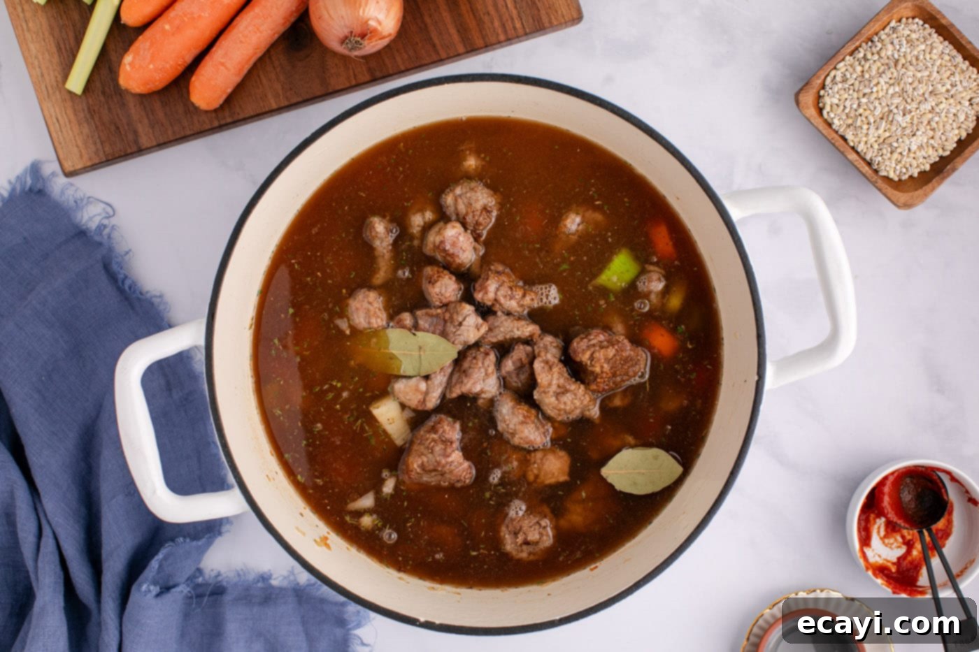 Wholesome Beef and Barley Comfort 12 Beef barley soup simmering with beef broth and bay leaves in a large stockpot.