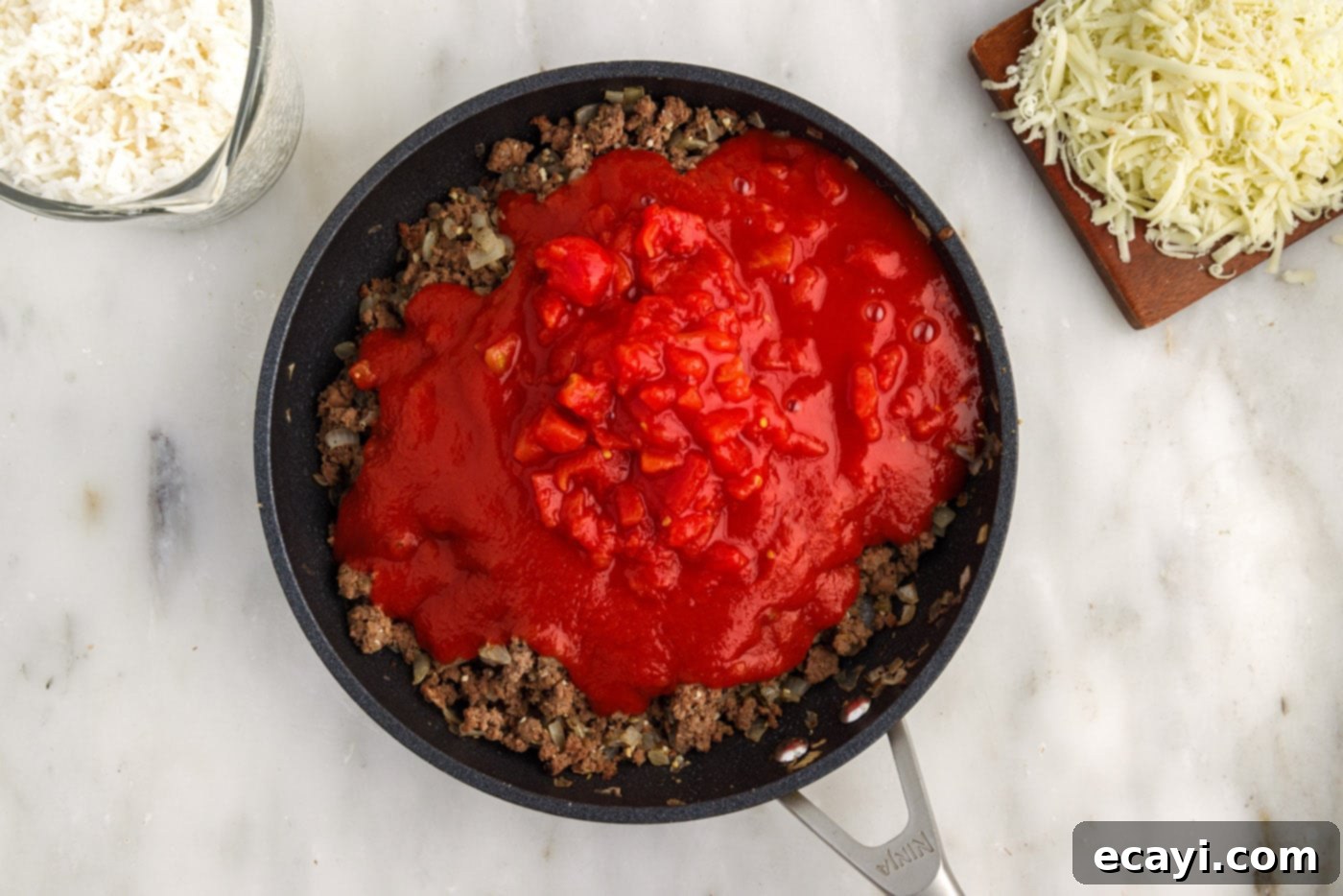 Hearty Cabbage Roll Bake 7 tomato sauce and diced tomatoes added on top of ground beef mixture in skillet