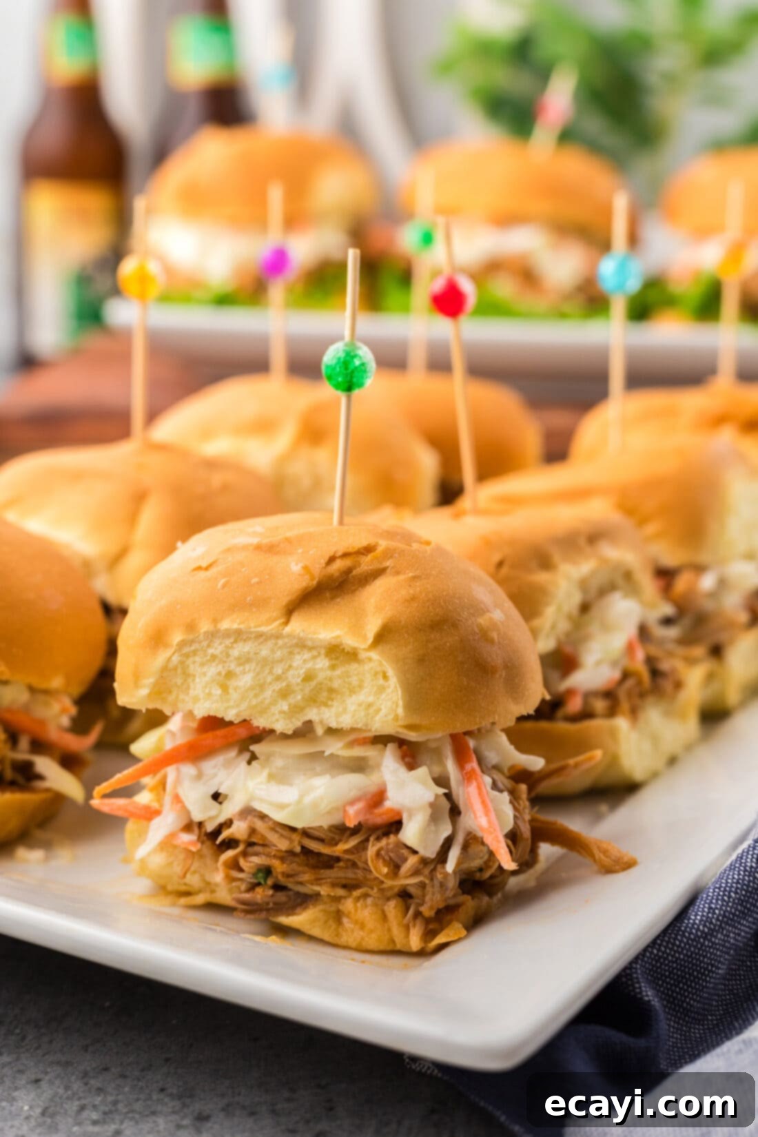 Mini BBQ Chicken Sandwiches 11 Close up photo of BBQ Chicken Sliders on a platter, highlighting the texture of the chicken and sauce.