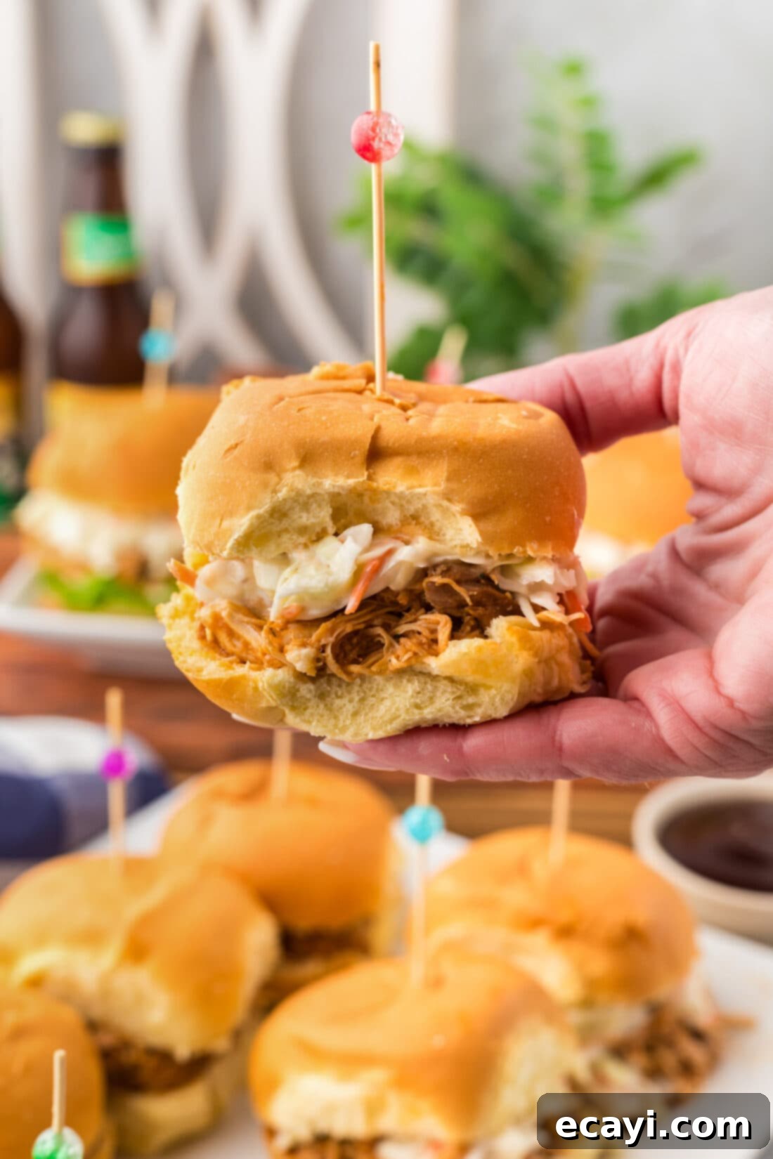 Mini BBQ Chicken Sandwiches 3 Hand holding up a BBQ Chicken Slider, showing the delicious filling and soft bun.