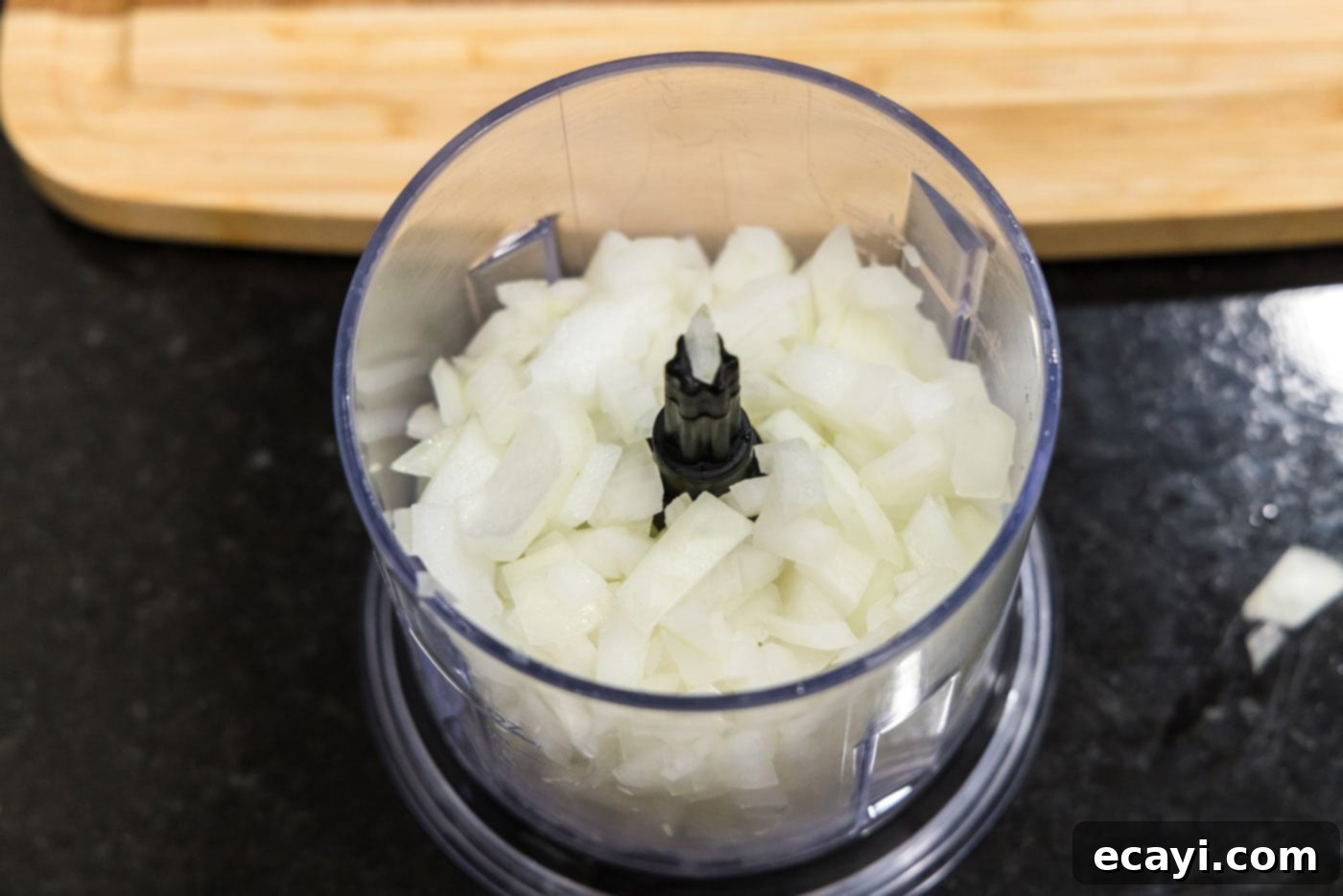Mini BBQ Chicken Sandwiches 5 chopped onion in food processor, showing coarsely chopped pieces.