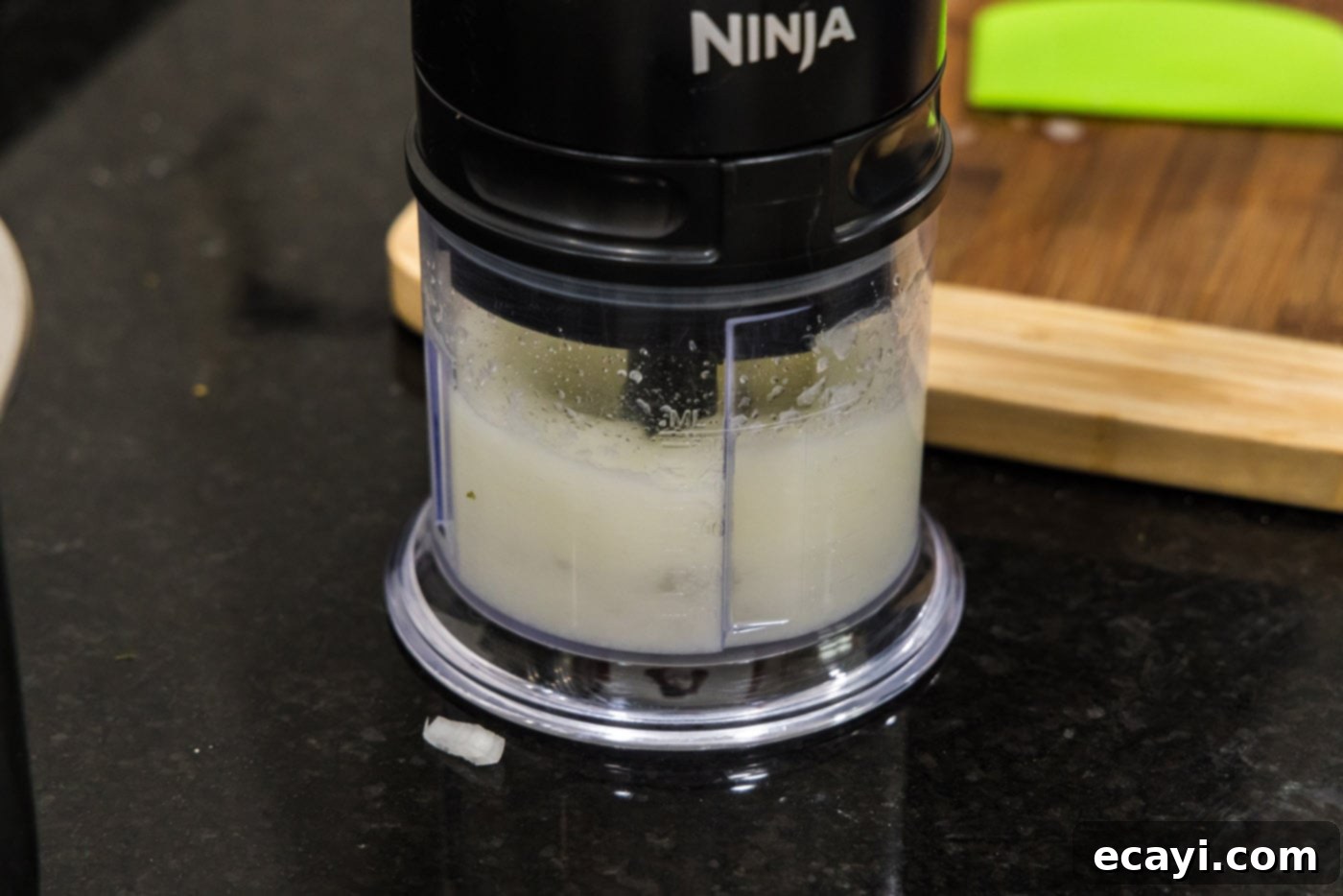 Mini BBQ Chicken Sandwiches 6 finely chopping onion in a food processor, demonstrating the process of mincing the onion.