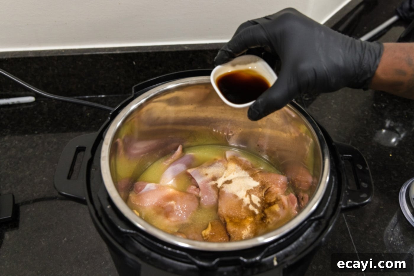 Mini BBQ Chicken Sandwiches 8 adding Worcestershire sauce to instant pot with chicken, illustrating the seasoning process.
