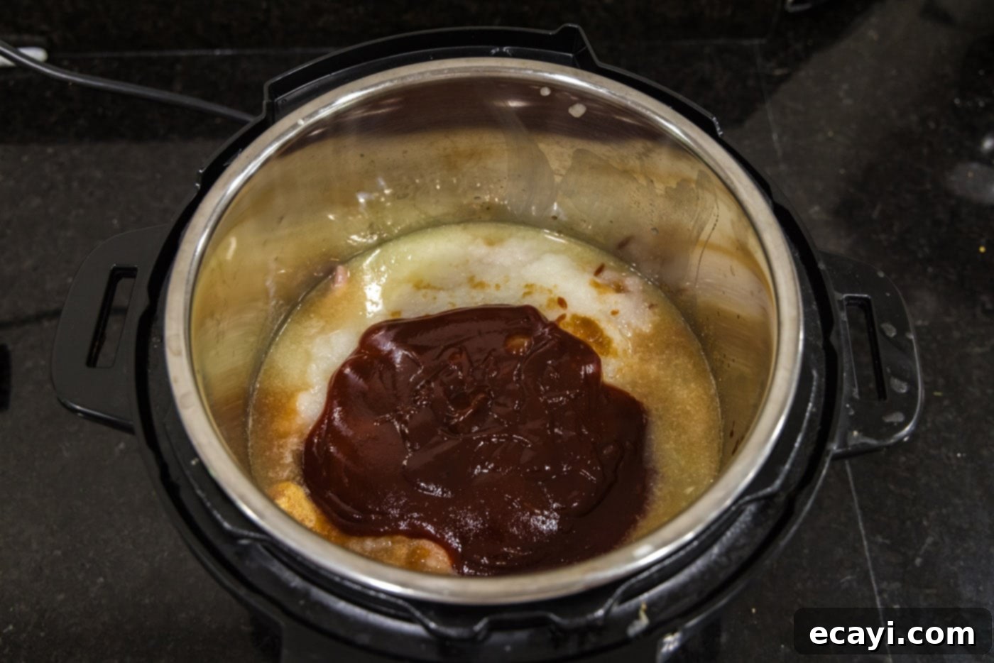 Mini BBQ Chicken Sandwiches 10 barbecue sauce on top of chicken mixture in instant pot, illustrating the final sauce layer.