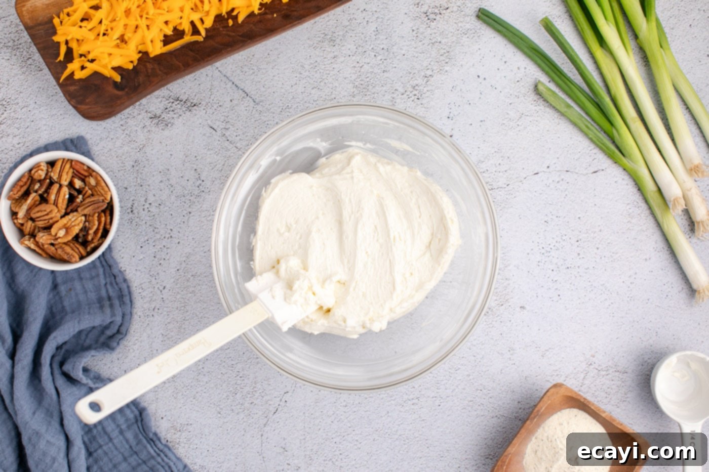 Touchdown Cheese Ball 9 rubber spatula in a bowl of cream cheese and sour cream mixture
