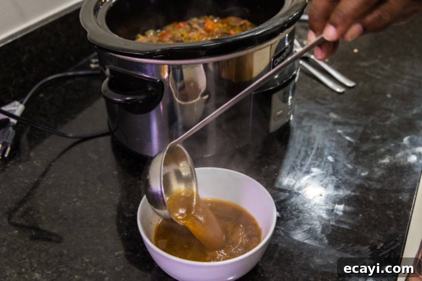 Golden Crispy Beef Carnitas 10 spooning excess liquid from beef carnitas in the slow cooker to reduce grease