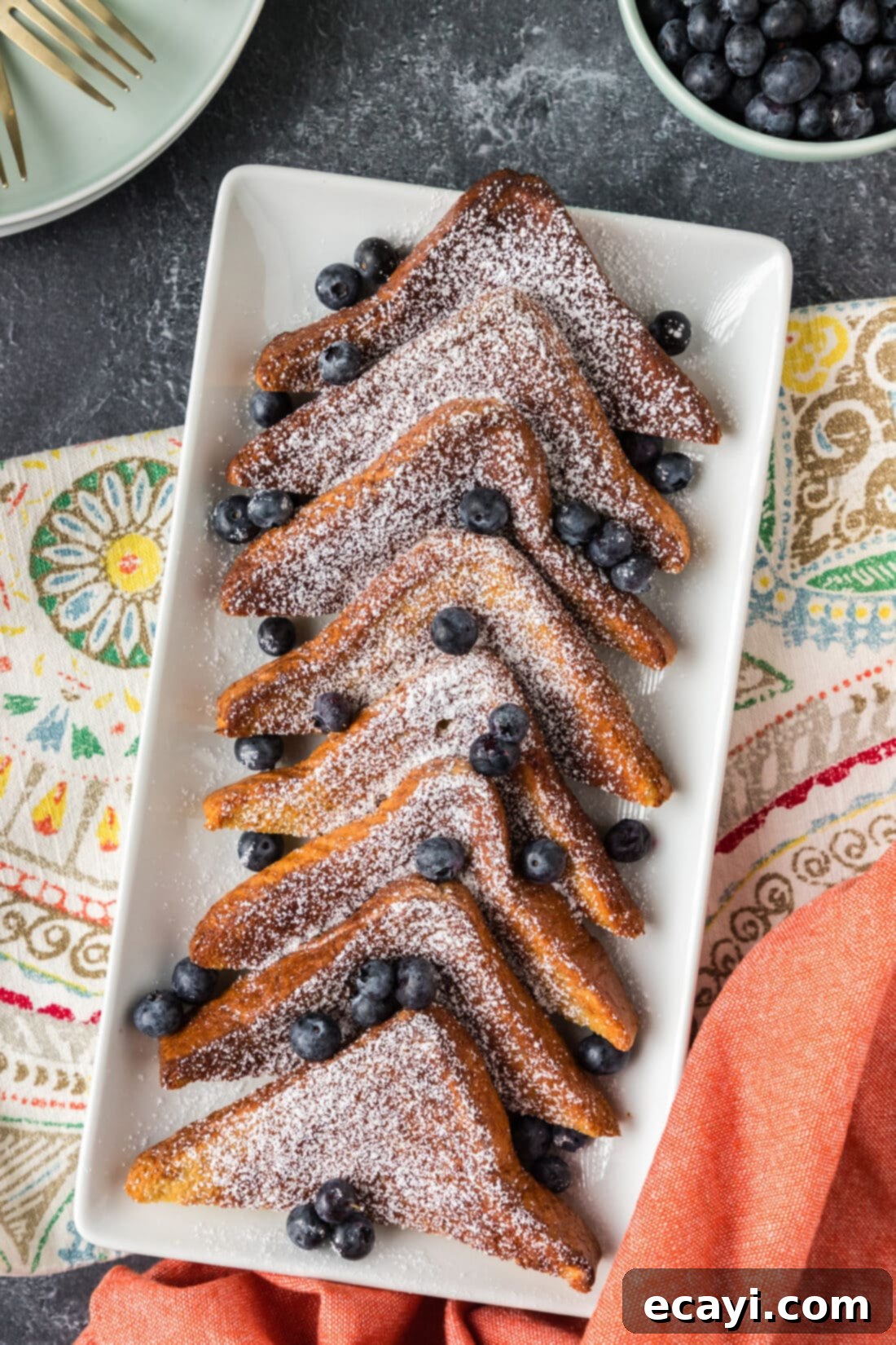 Perfect Air Fryer French Toast 11 A beautiful platter of golden Air Fryer French Toast, garnished with powdered sugar and fresh berries, ready to be served.