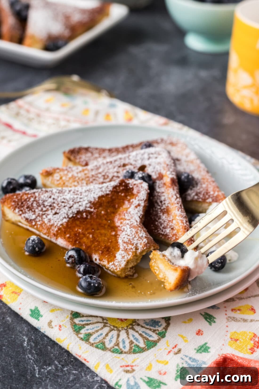 Perfect Air Fryer French Toast 3 A piece of perfectly cooked Air Fryer French Toast on a fork, showing its soft interior and crispy crust.