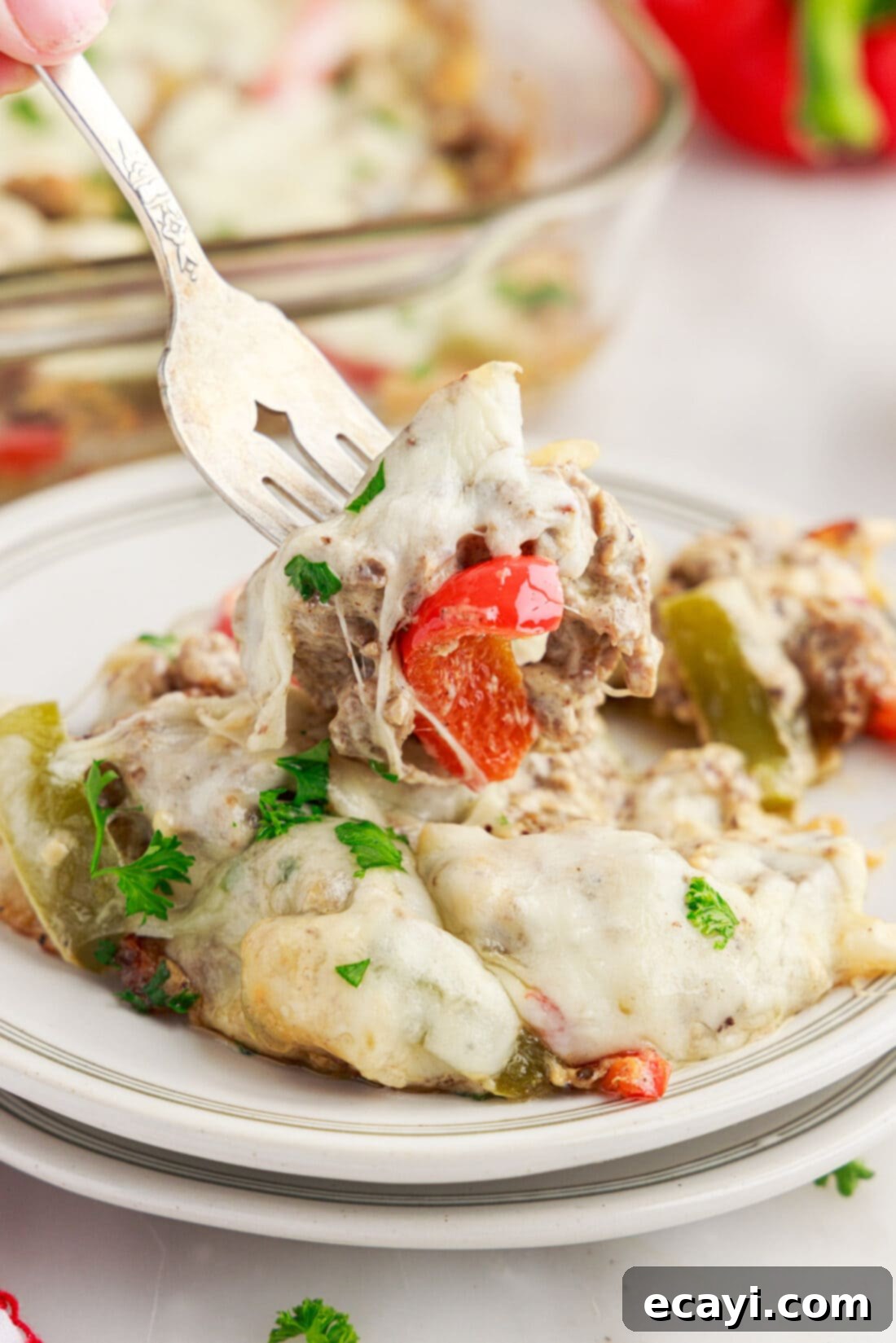 Hearty Philly Cheesesteak Casserole 2 Forkful of Philly Cheesesteak Casserole being lifted off a plate of Philly Cheesesteak Casserole