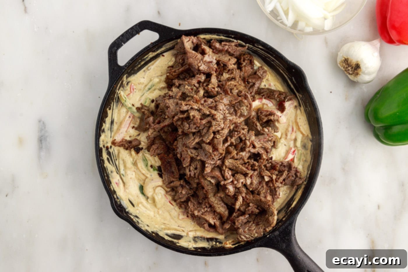 Hearty Philly Cheesesteak Casserole 13 sliced flank steak added on top of cream cheese and veggie mixture for casserole