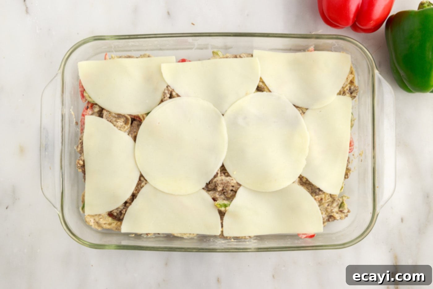 Hearty Philly Cheesesteak Casserole 15 provolone cheese slices layered on top of Philly Cheesesteak Casserole before baking