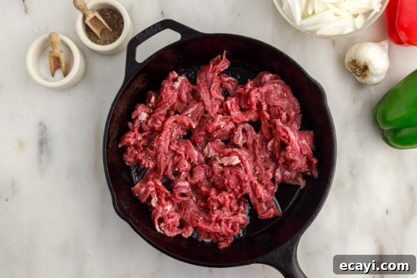 Hearty Philly Cheesesteak Casserole 7 searing flank steak slices in a skillet for the casserole