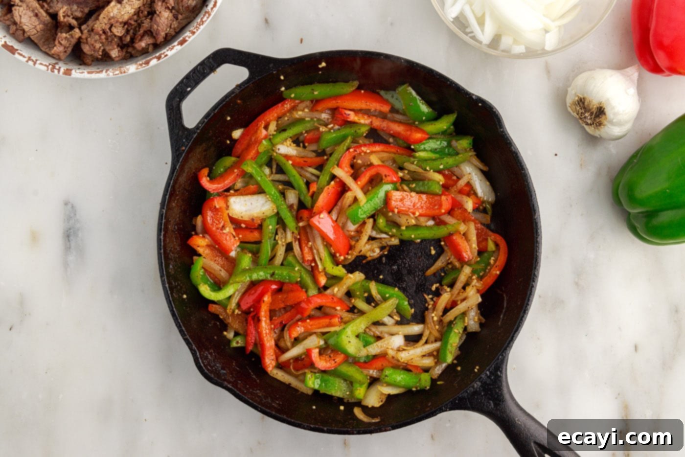Hearty Philly Cheesesteak Casserole 10 cooked veggies in a skillet for cheesesteak casserole