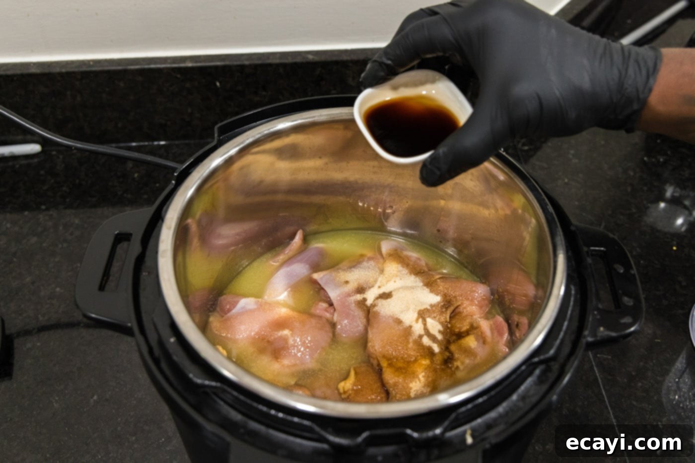 Smoky BBQ Chicken Sandwich 8 Adding Worcestershire sauce and liquid smoke to the chicken in the Instant Pot.