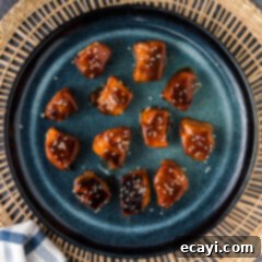 Salmon Morsels 14 Salmon Bites on a blue plate, garnished with sesame seeds and green onions.