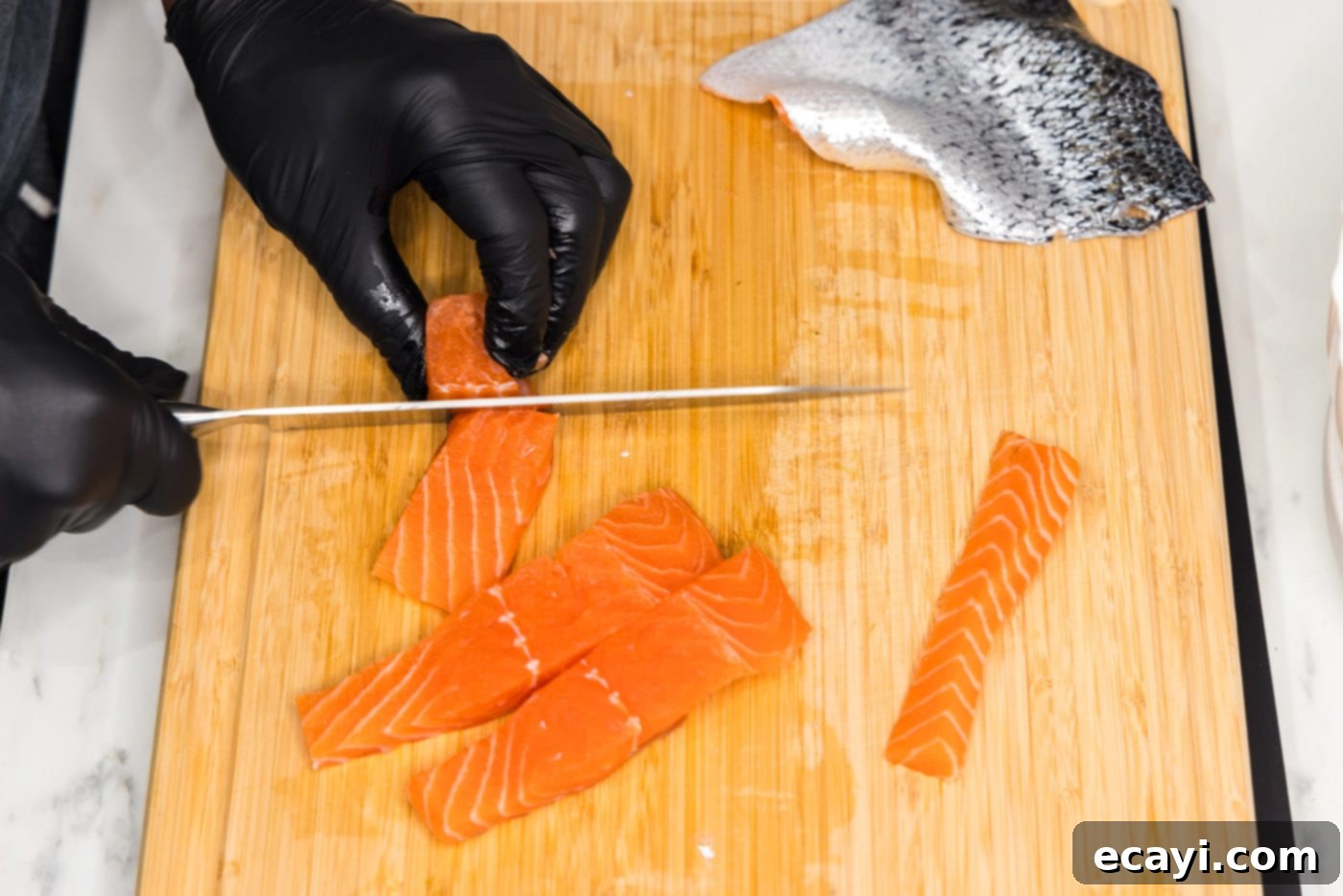 Salmon Morsels 7 Cutting the salmon strips into perfectly even 2-inch cubes for the salmon bites recipe.