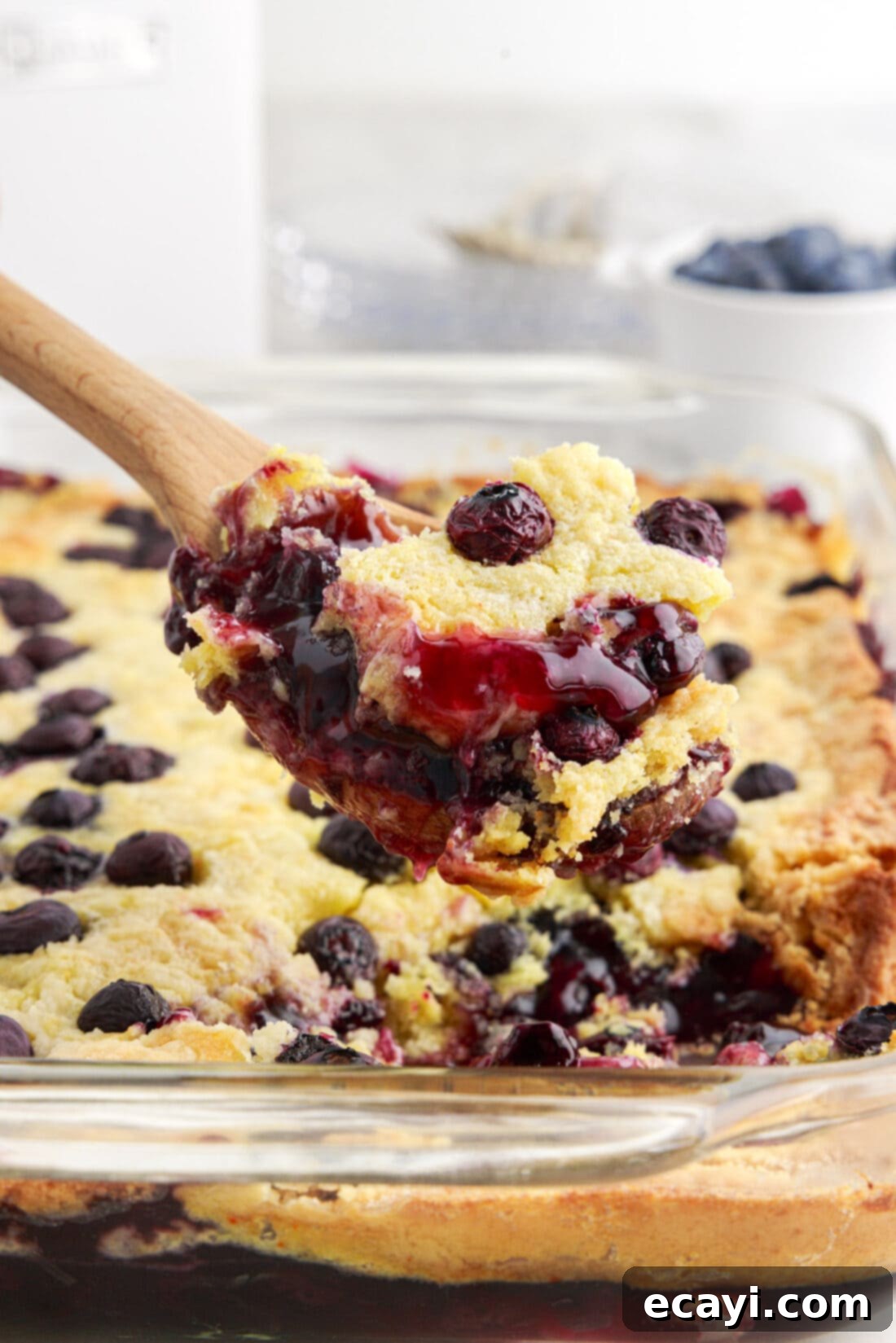 Effortless Blueberry Delight 2 Spoonful of Blueberry Dump Cake being lifted out of the pan