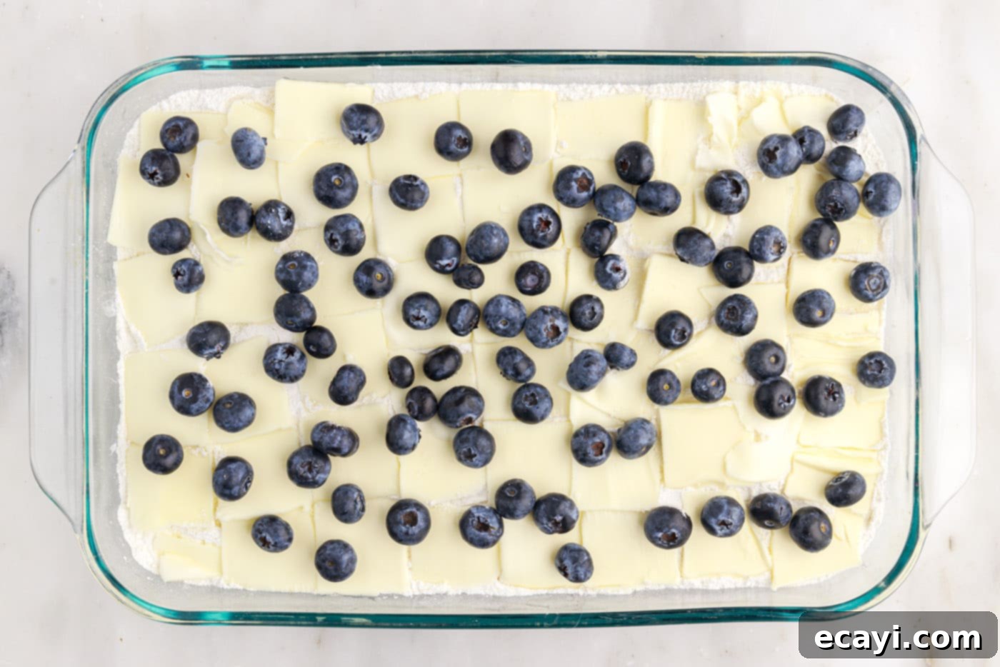 Effortless Blueberry Delight 7 blueberry speckled on top of butter and cake mix in a baking dish