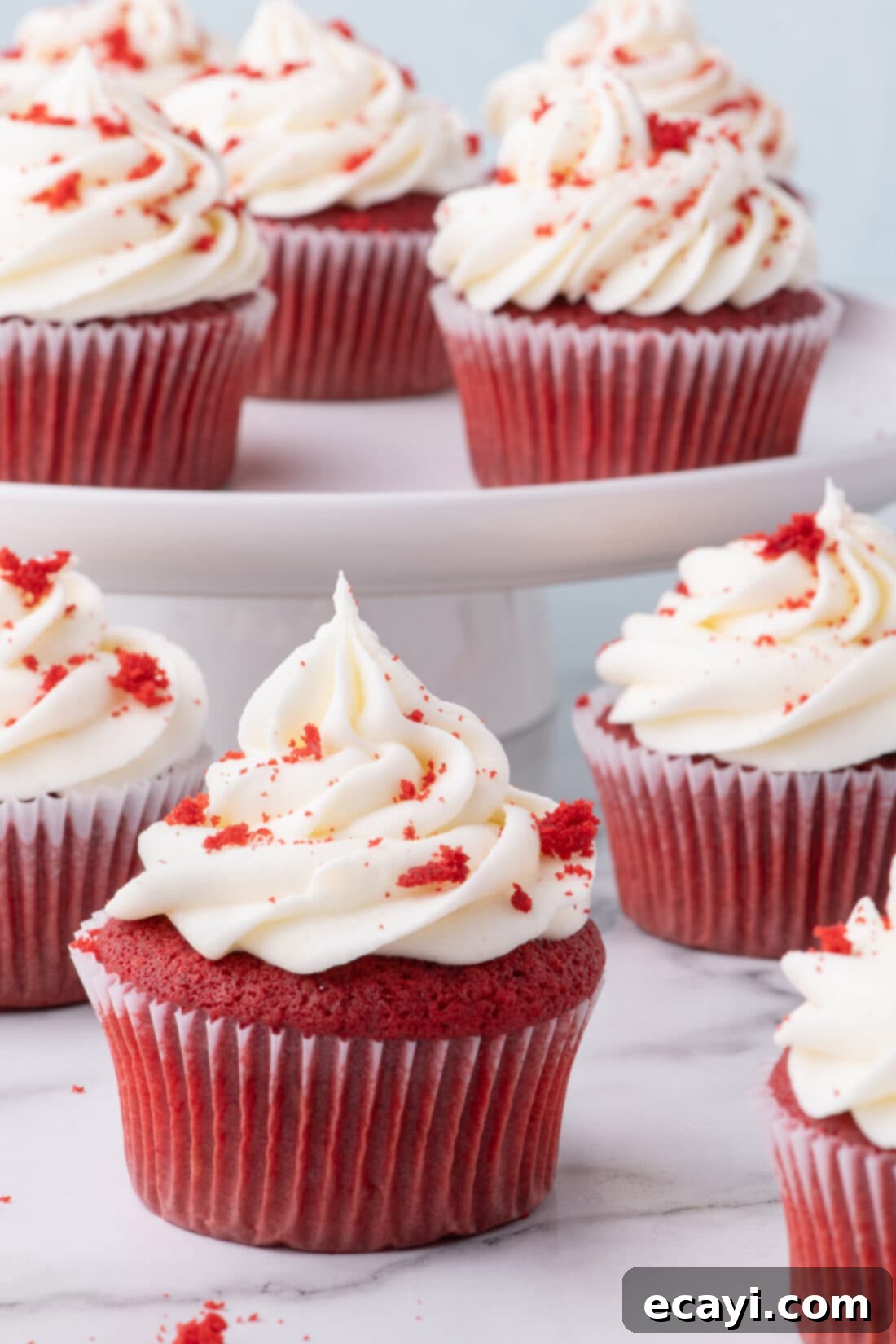Decadent Red Velvet Treats 2 Classic Red Velvet Cupcakes topped generously with fluffy cream cheese frosting, ready to be enjoyed.