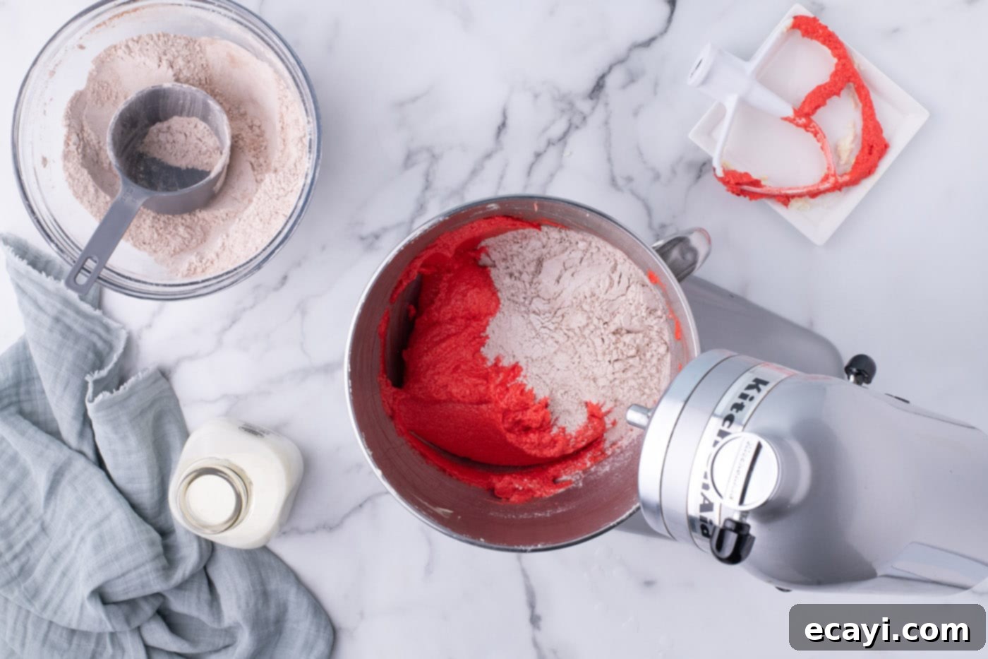 Decadent Red Velvet Treats 11 Carefully mixing 1/3 of the dry ingredients into the red velvet cupcake batter, ensuring not to overmix.