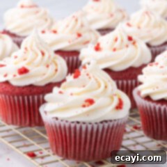 Decadent Red Velvet Treats 20 A cluster of freshly baked and frosted Red Velvet Cupcakes arranged on a wire rack.