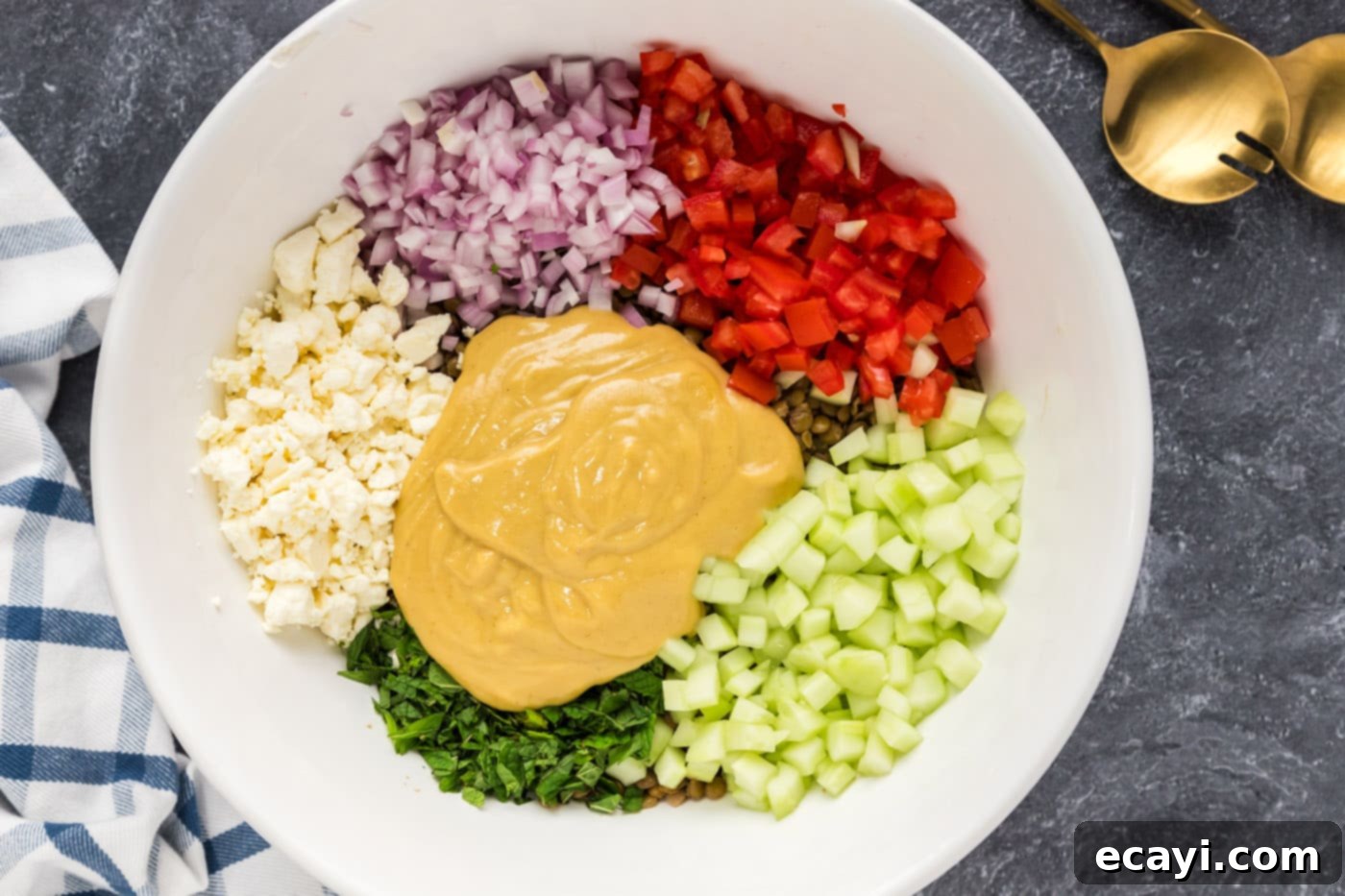 Zesty Lemon Herb Lentil Salad 8 adding dressing to lentil salad ingredients in a mixing bowl