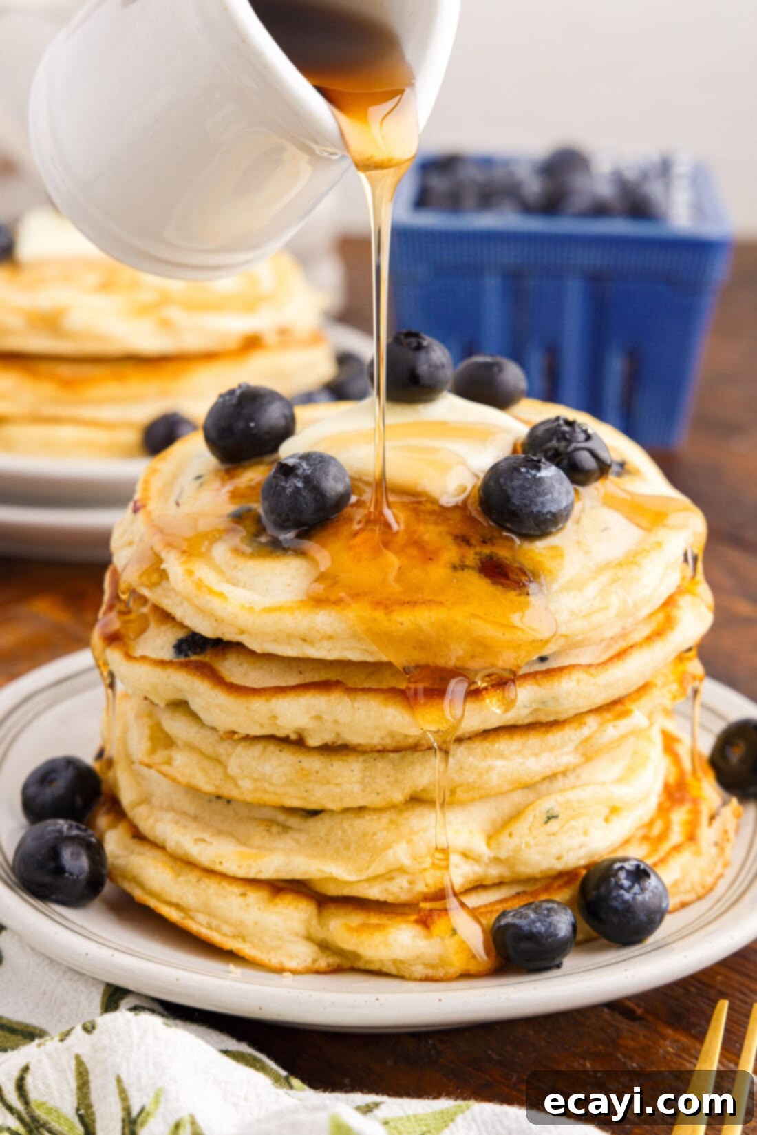 Bursting Blueberry Breakfast Flapjacks 2 Syrup being poured over a stack of blueberry pancakes