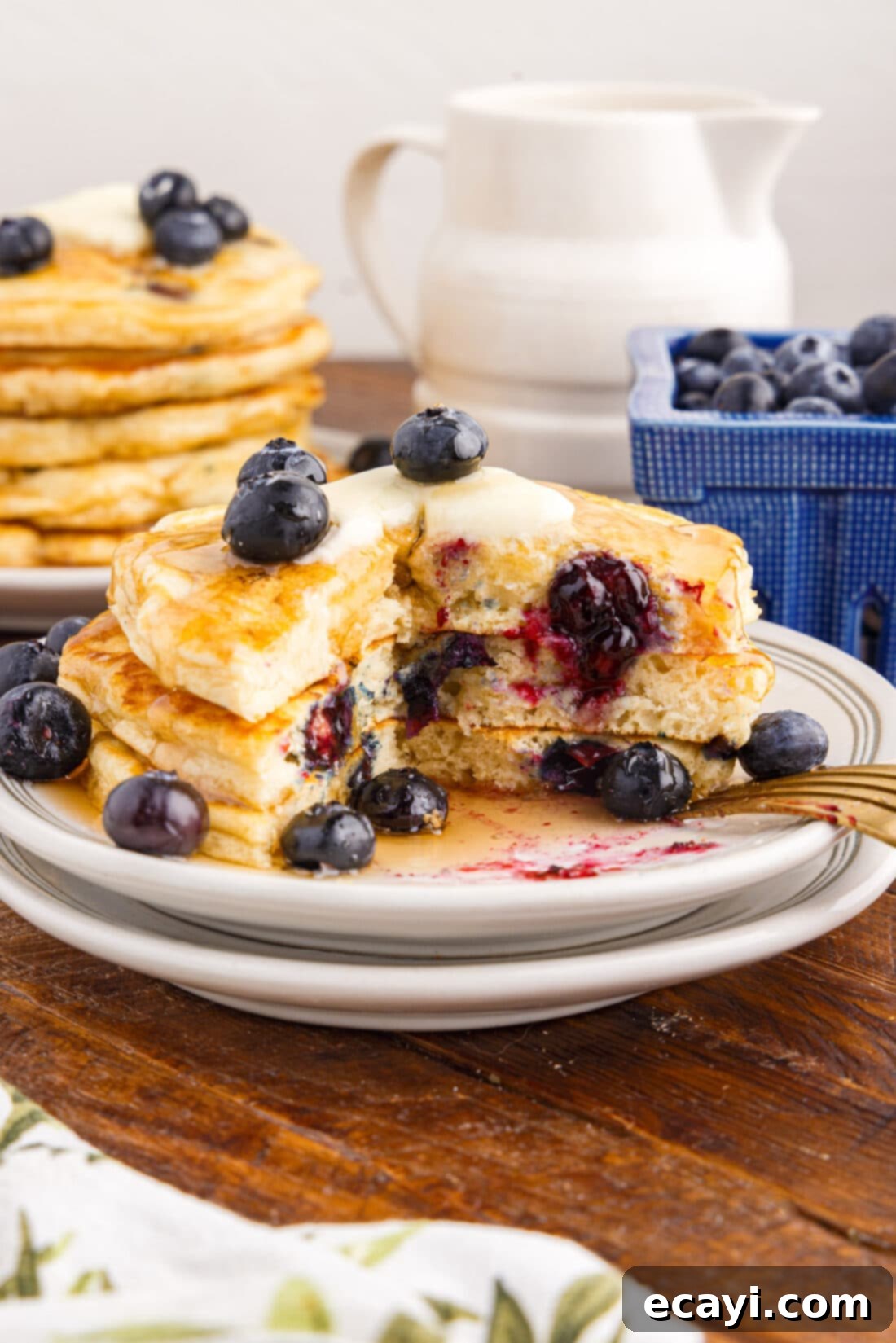Bursting Blueberry Breakfast Flapjacks 12 Stack of Blueberry Pancakes on a plate with a bite removed