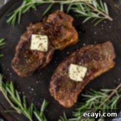 Perfect Sous Vide Steak 12 Two Sous Vide Steaks on a platter topped with melted butter and fresh rosemary.