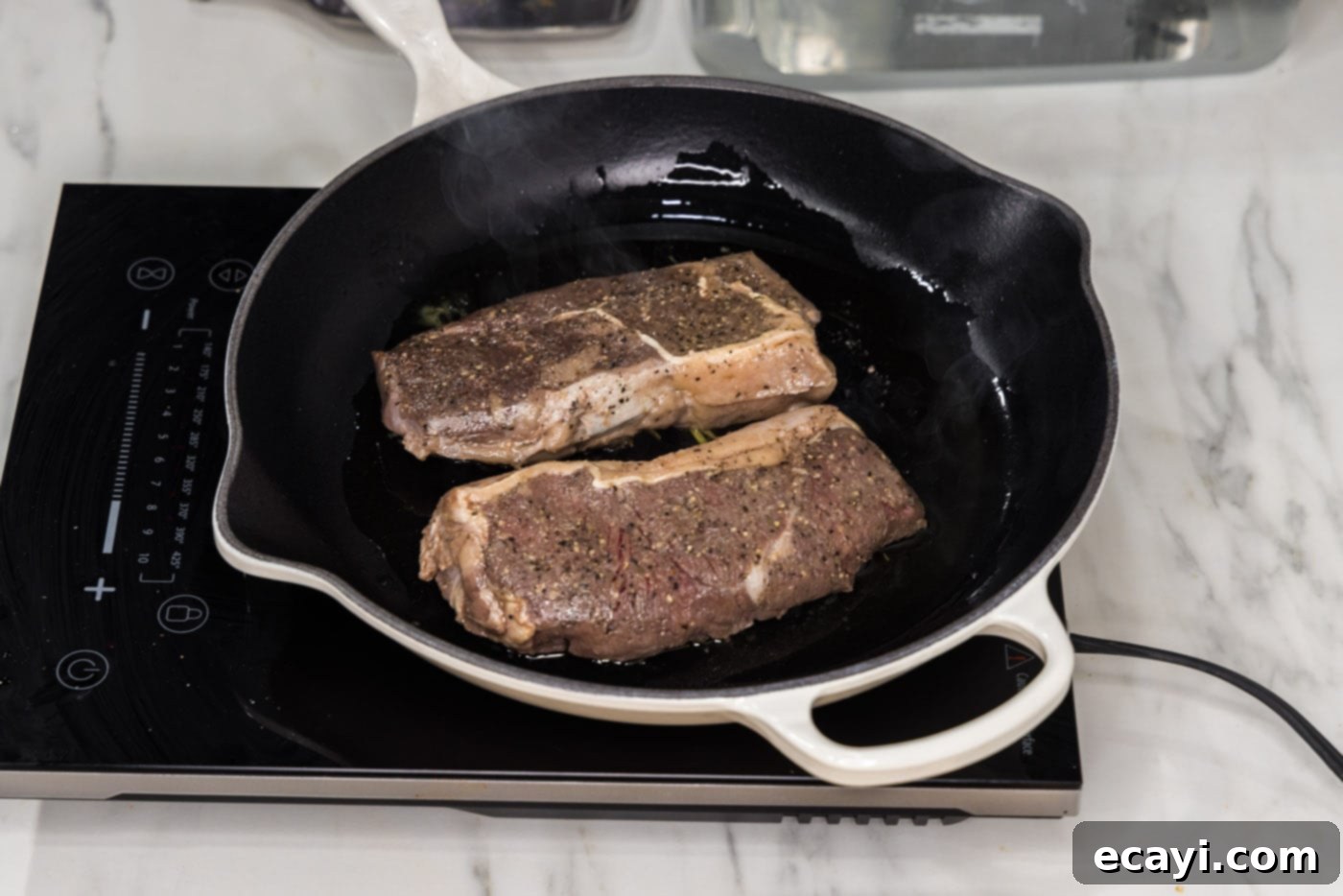 Perfect Sous Vide Steak 9 Searing two sous vide steaks in a hot skillet with olive oil to create a caramelized crust.