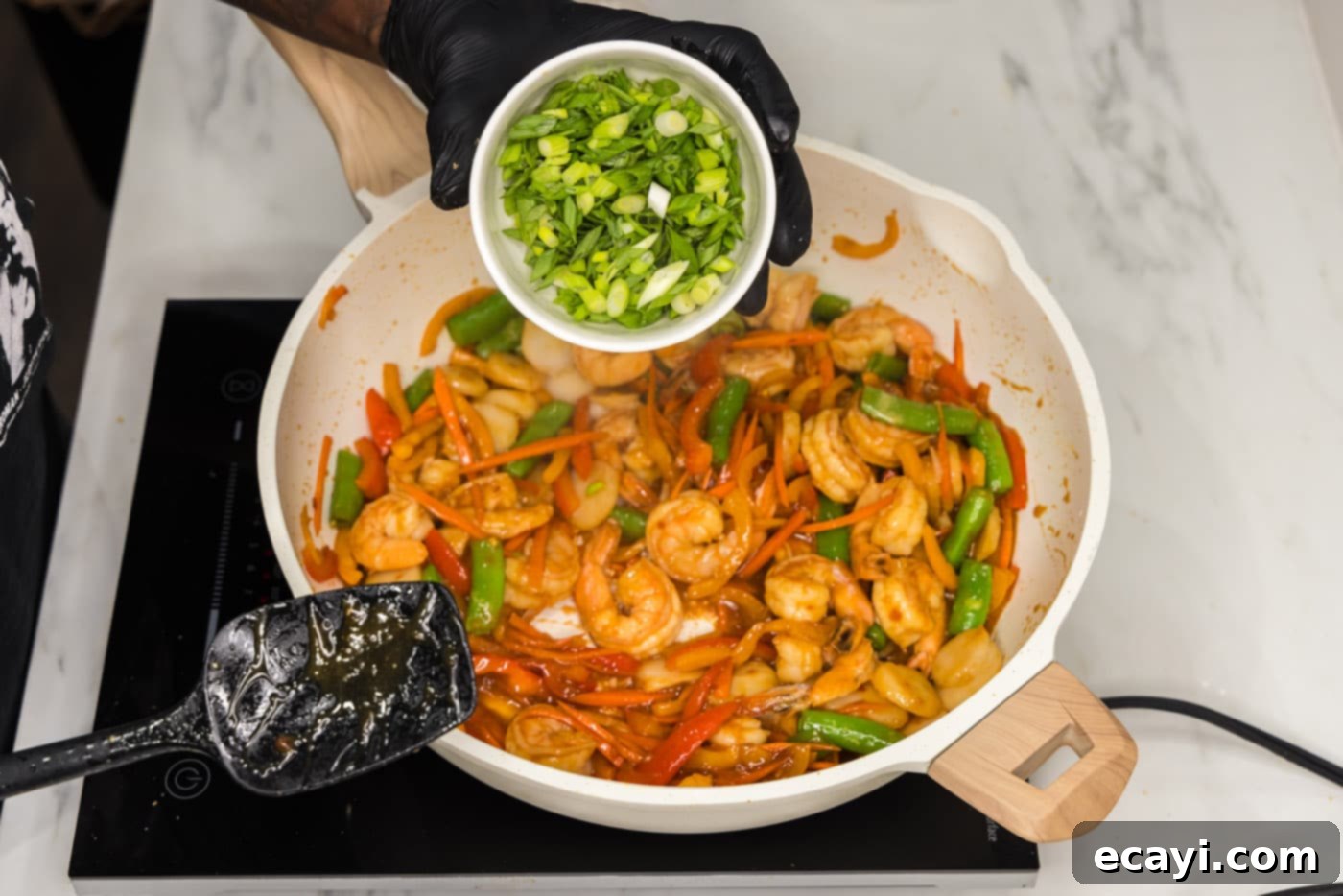 Quickfire Shrimp Stir-Fry 11 green onions sprinkled over top skillet of shrimp and stir fry vegetables for garnish