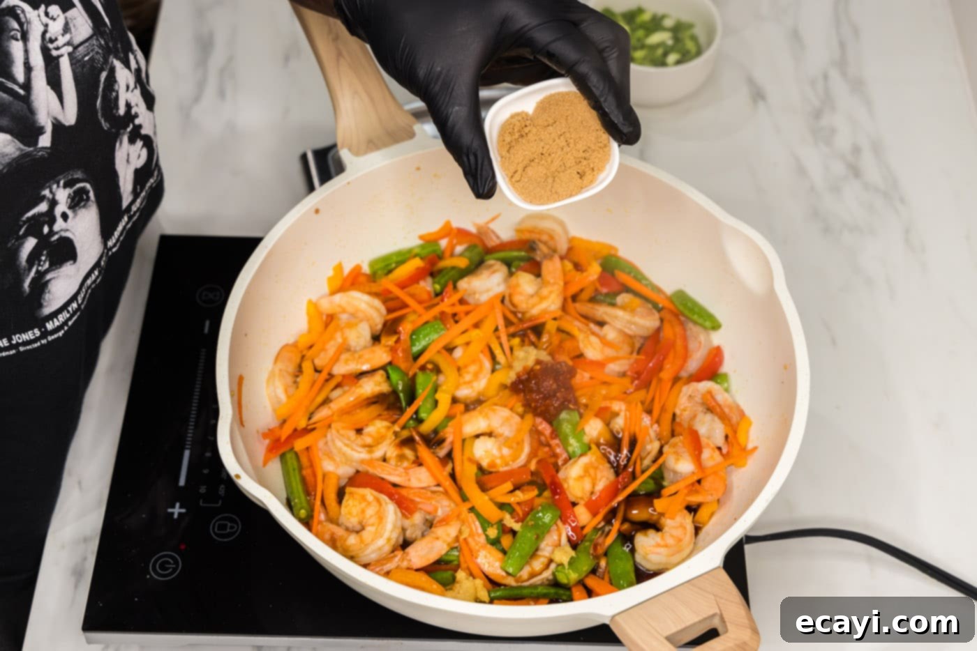 Quickfire Shrimp Stir-Fry 8 adding brown sugar to shrimp stir fry in a skillet for balance