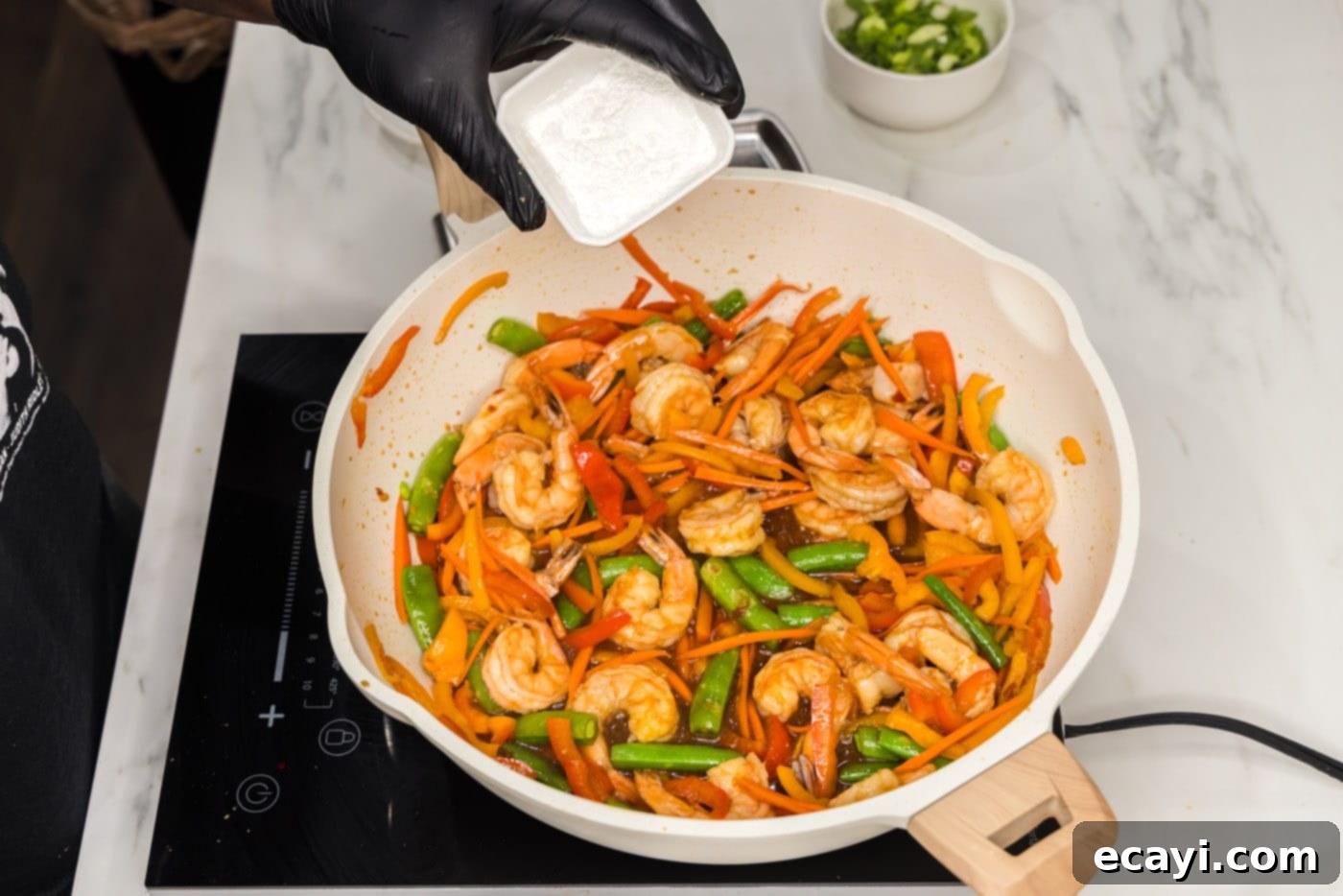 Quickfire Shrimp Stir-Fry 9 adding cornstarch to thicken the stir fry sauce in a skillet