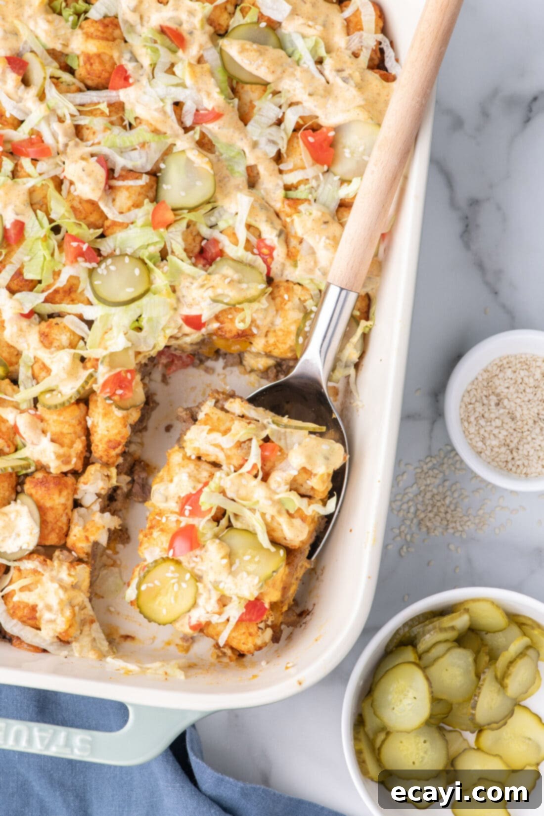 Special Sauce Cheeseburger Casserole 3 Spoonful of Big Mac Casserole resting in a casserole dish, showing the tater tot and cheese layers