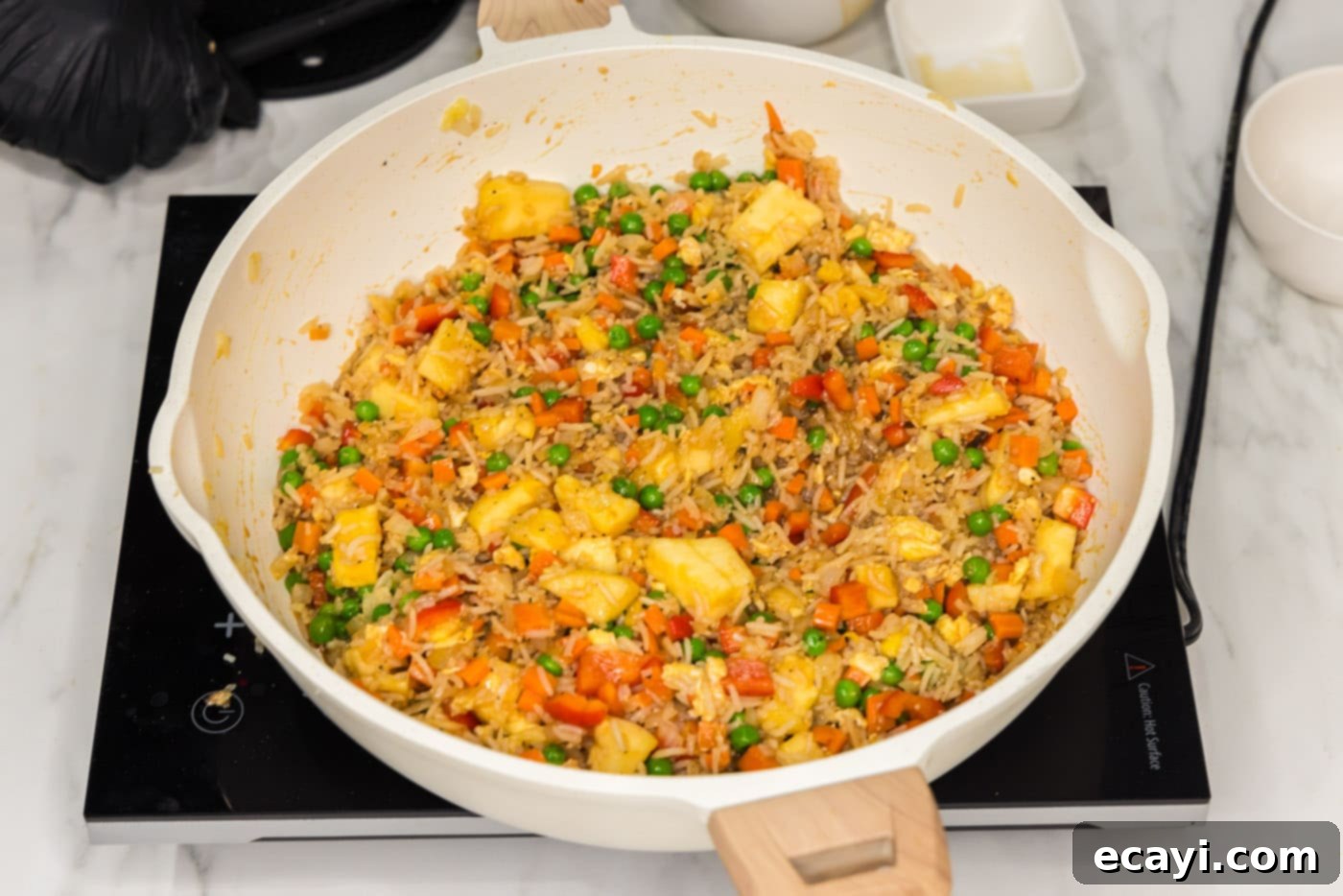 Sun-Kissed Pineapple Rice 14 The finished Pineapple Fried Rice, vibrant and aromatic, shown in a large skillet, ready to be dished out and enjoyed.