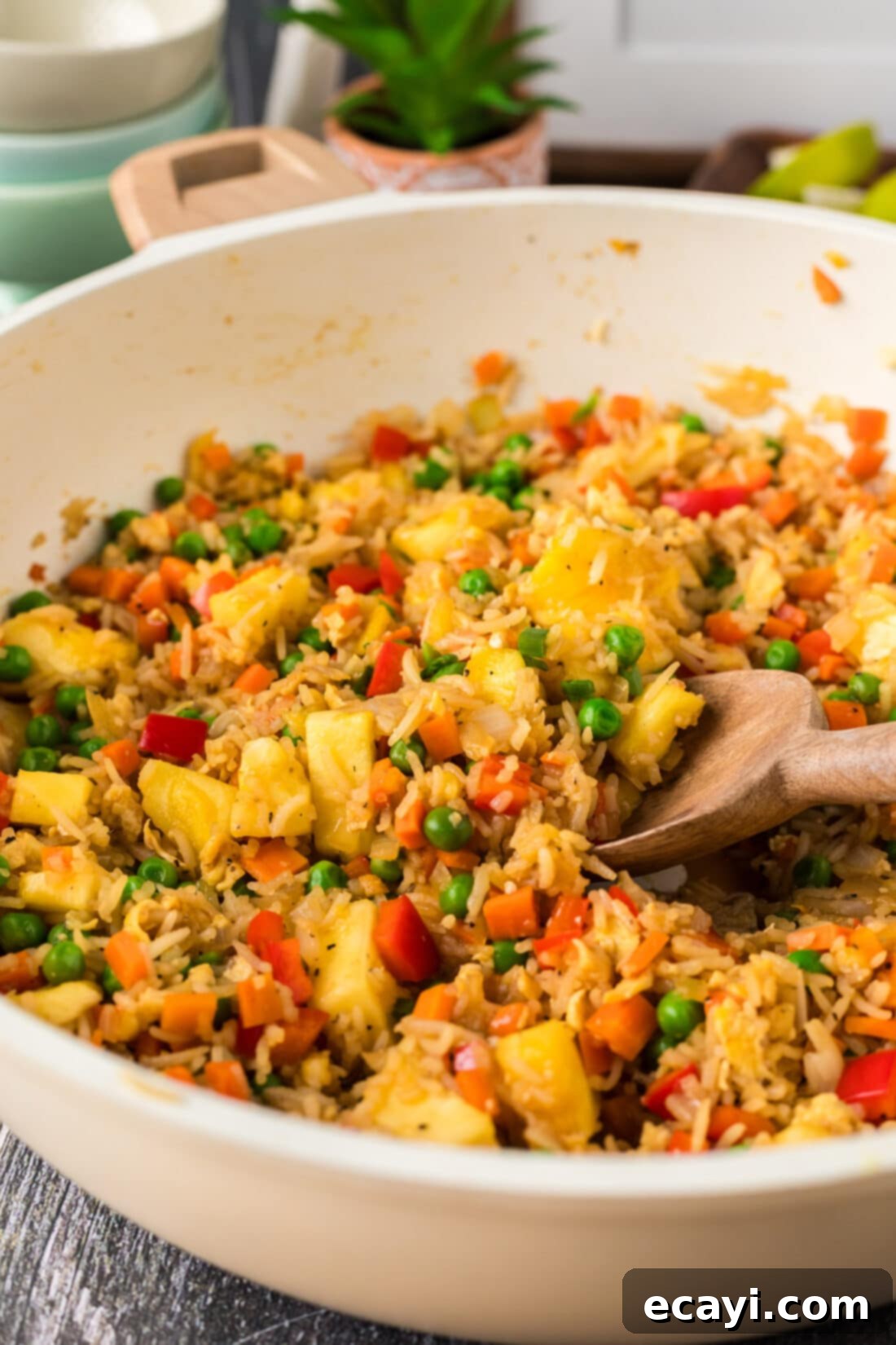 Sun-Kissed Pineapple Rice 15 A close-up view of Pineapple Fried Rice in a large skillet, showing the glossy grains, distinct vegetables, and pineapple chunks, ready to be served.